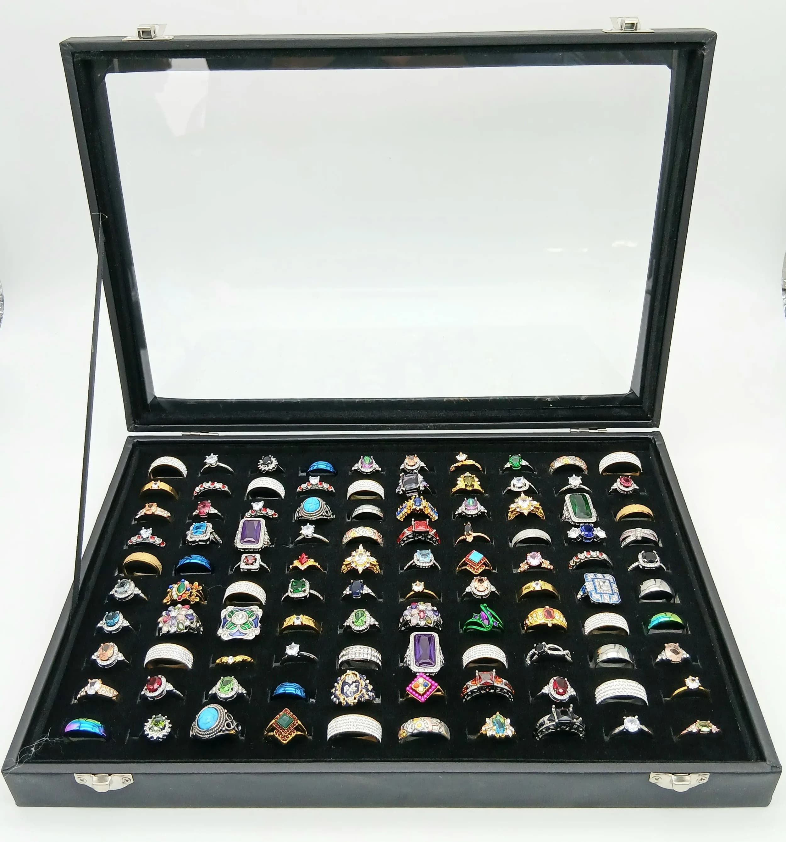 A Jewellery Display Case with 100 Rings! An absolutely fabulous lot with different colored stones to acrylic/resin decoration. All types of stone cuts with gilded and white metal shanks of different design. Sizes range from small to large. All rings in excellent condition. Case size - 35 x 24cm.