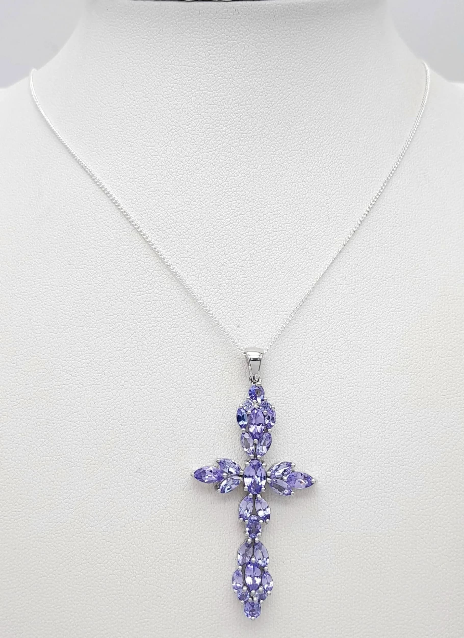 A Beautiful Sterling Silver and Tanzanite Cross Pendant Necklace-46cm Length Chain. The Cross measures a 4.7cm drop and is 2.4cm wide. Gross weight 6.02 grams.