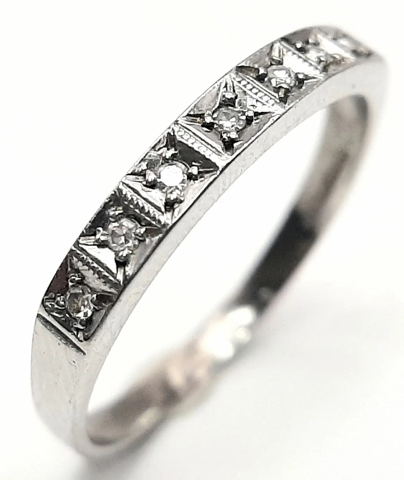 A 9K White Gold Seven Stone Diamond Ring. Size R. 1.8g.