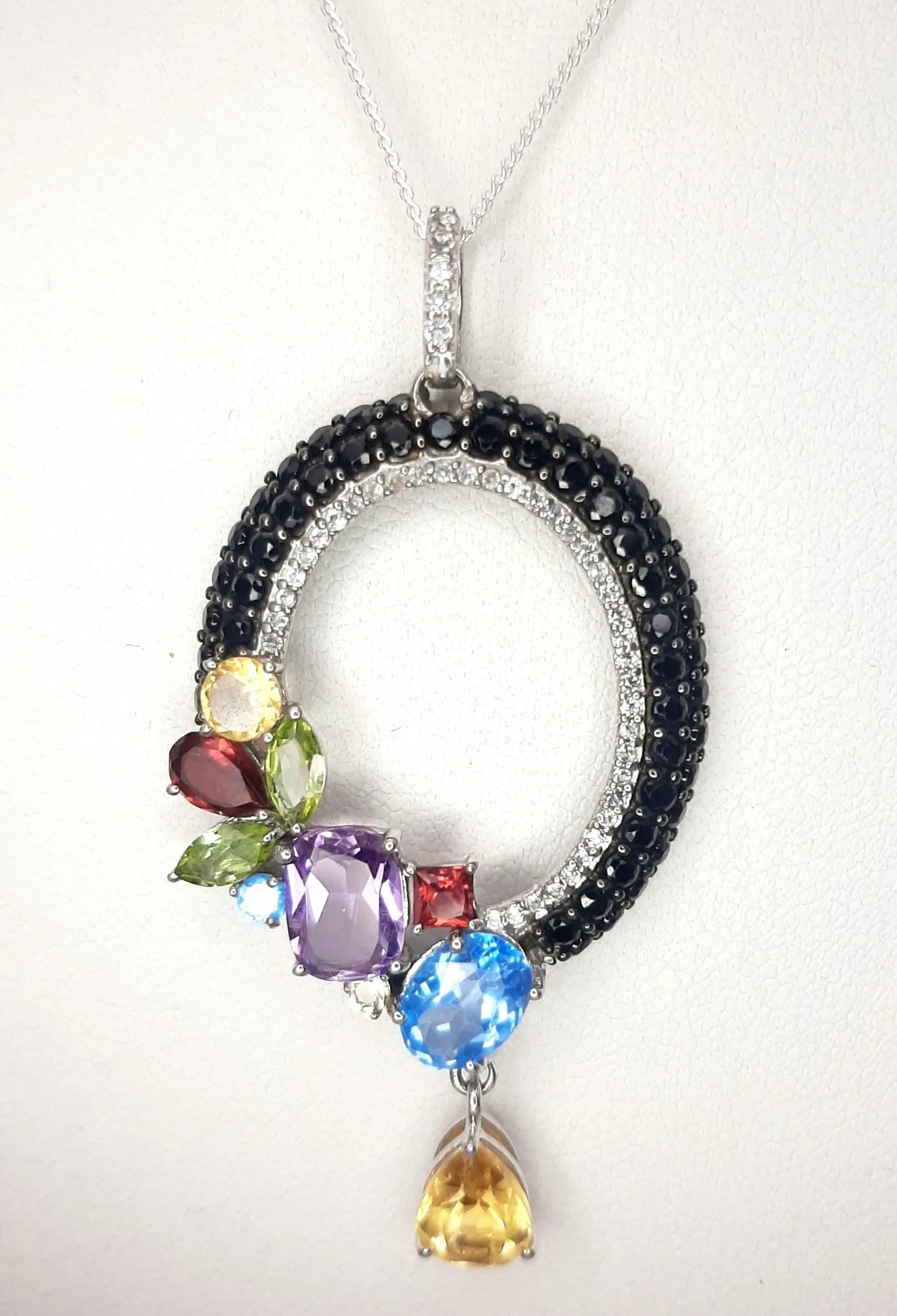 A Pretty Sterling Silver Multi-Colour Semi-Precious Gemstone Pendant Necklace-46cm Length. The Pendant measures a 5.4cm drop and is 2.7cm wide, being set with Citrine, Blue and White Topaz, Garnet, Amethyst, Peridot and Black Onyx. Gross weight 7.2 grams.