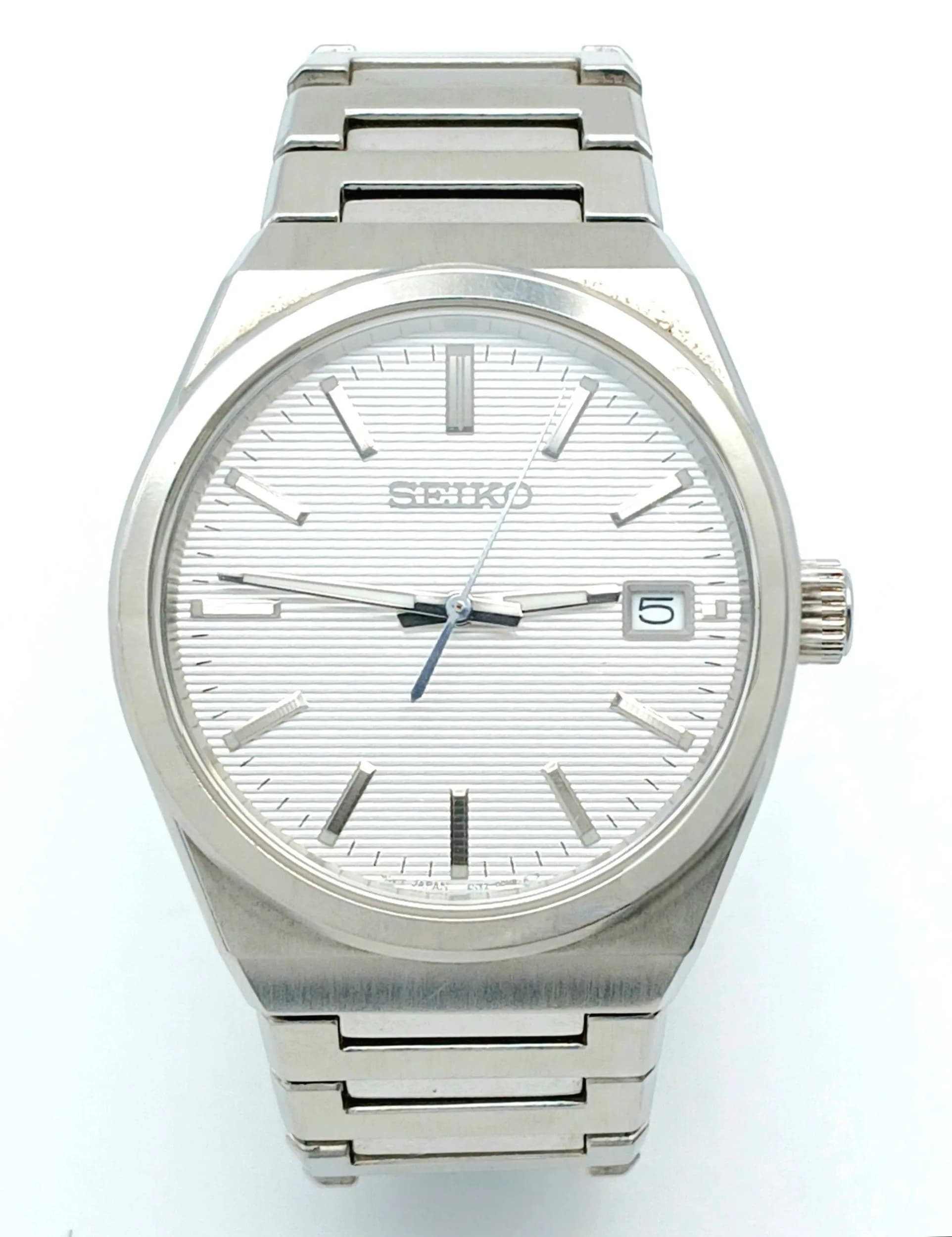 A Classic Seiko Quartz Gents Watch. Model 6N52-00H0. Stainless steel bracelet and case - 38mm. White dial with vertical lines and date date window. In good condition and working order.