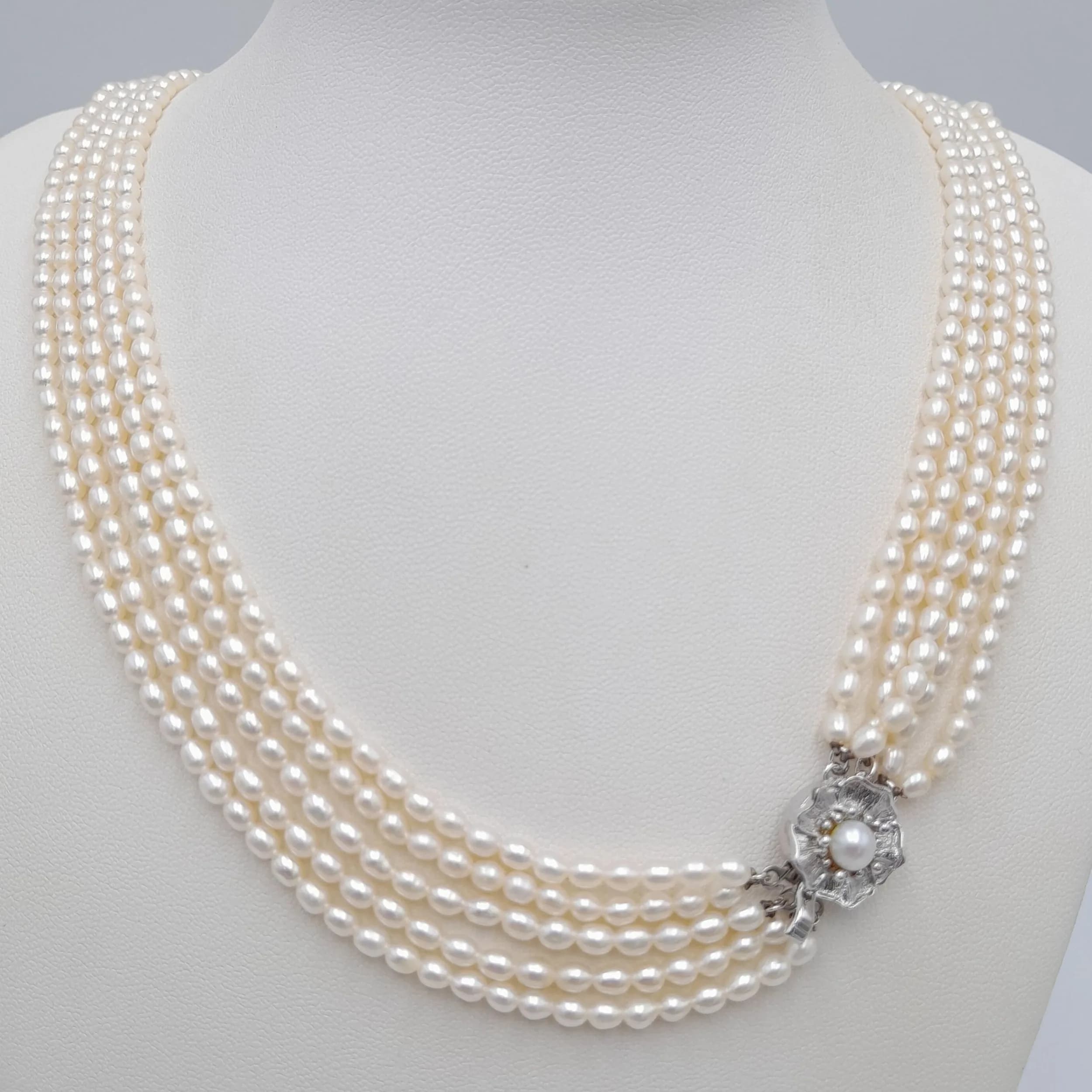 An impressive Five Strand freshwater Pearl statement Necklace, with a decorative silver tone floral clasp set with a central pearl. Approx. 61cm length. Please see photos or request a condition report.