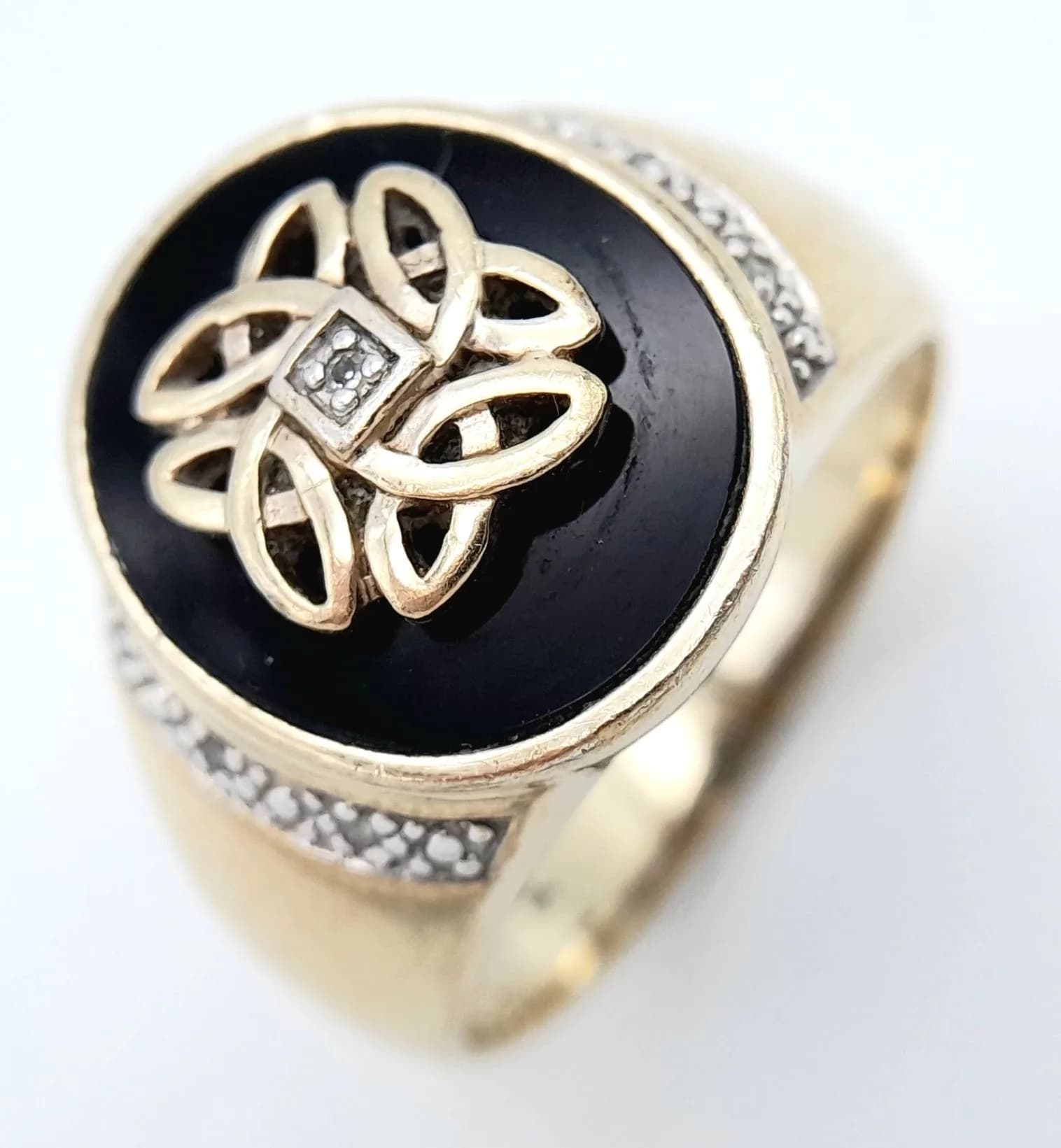 A Unique Vintage Gold Gilded Sterling Silver Black Onyx Diamond Set Celtic Design Spinner Ring Size X1/2. The Ring measures 1.7cm Length at the Crown being set with a centre Diamond with a Celtic Design Spinner surrounding on Black Onyx. Gross weight 9.38 grams.