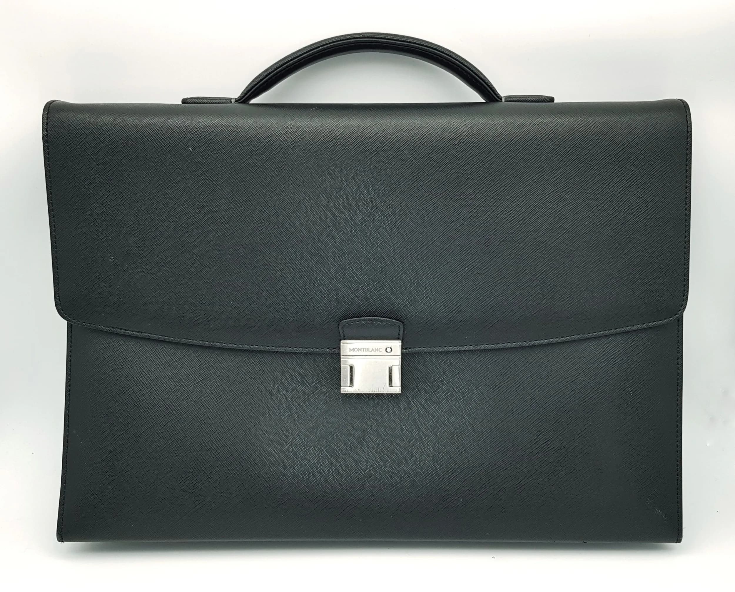 A Montblanc Sartorial Black Leather Briefcase. Black leather exterior with silver-tone hardware, leather top handle, flap closure with push-lock fastening and fittings for a shoulder strap. Opens to a black Montblanc monogram textile interior with two main compartments, a zipped inner pocket and multiple open side pockets. Rear open slip pocket. Approx. 40cm length x 29cm height. Signs of wear to the corners and a few light white marks to the leather exterior - Please see photos or request a condition report. Ref: 29715.