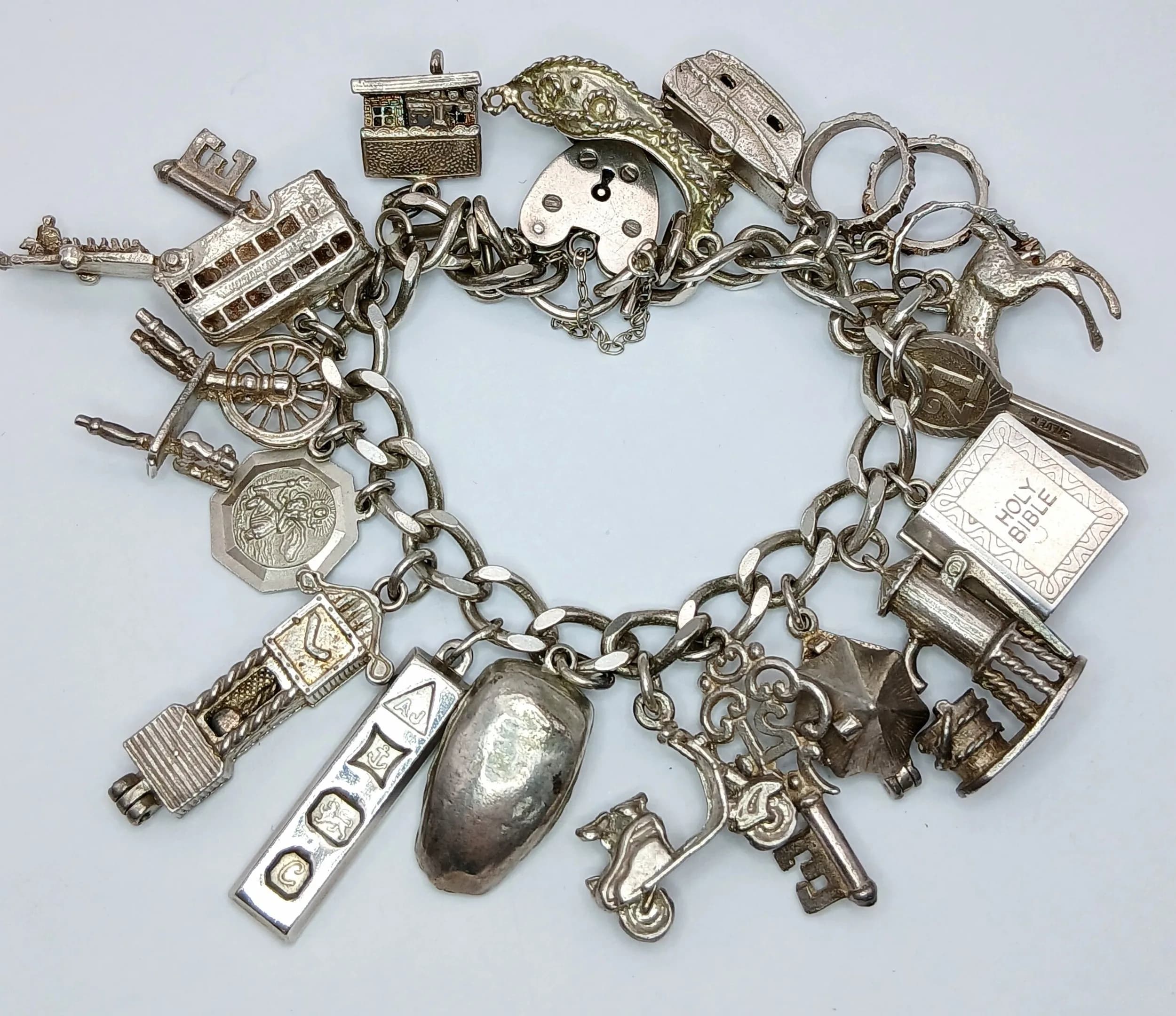 Vintage SILVER CHARM BRACELET. Full of Unusual and interesting SILVER CHARMS to include: Vespa, Row Boat , Ingot, Caravan, Bible, Saint Christopher, Water Pump... 66.7g total weight.