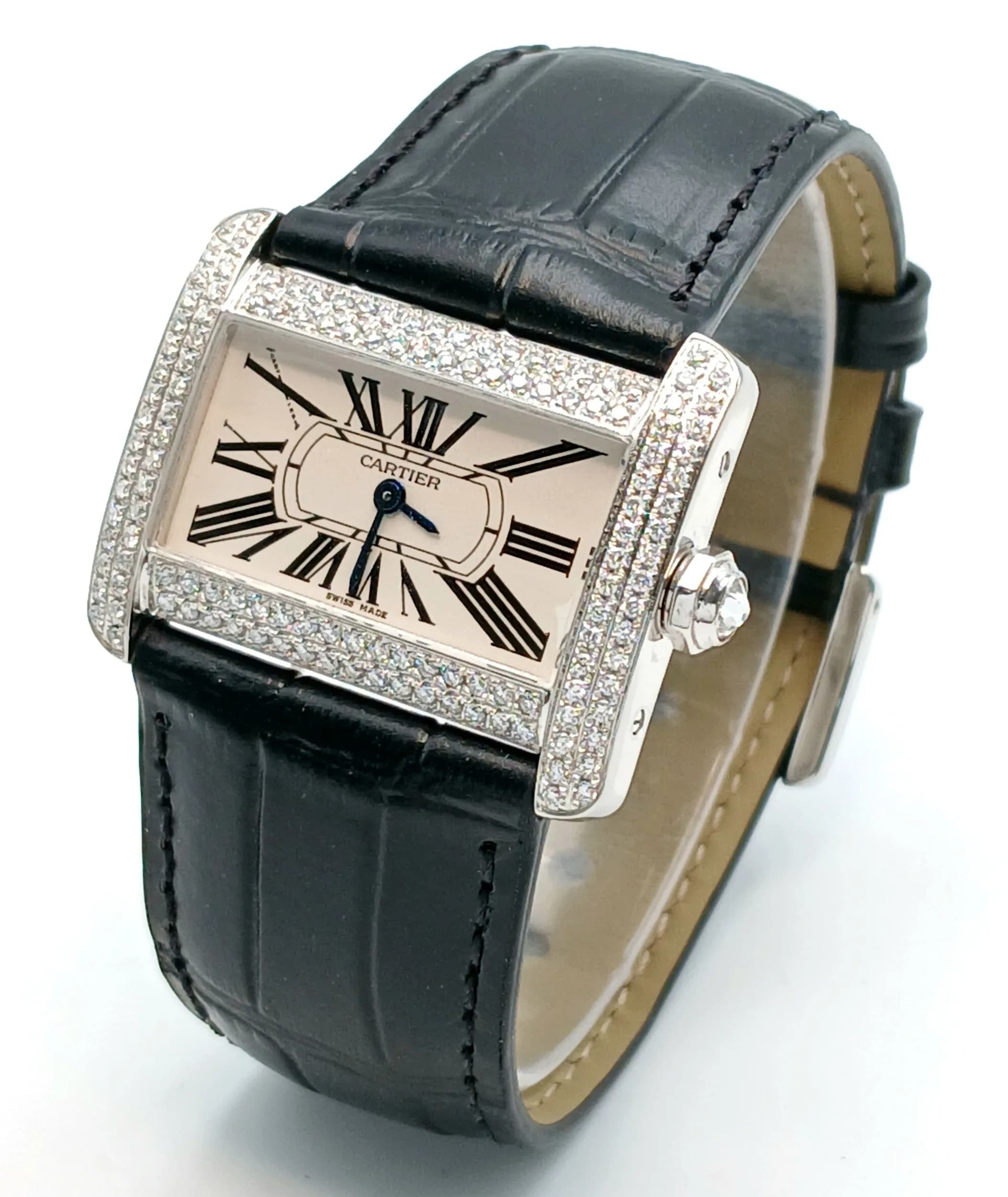 A Cartier Tank Divan Diamond Quartz Ladies Watch. Model 2599. Black leather strap. Stainless steel case - 32mm x 25mm. White dial with Roman Numerals. Two row diamond encrusted outer case. In working order. Note: The outer case diamonds have been professionally custom fitted with natural diamonds.