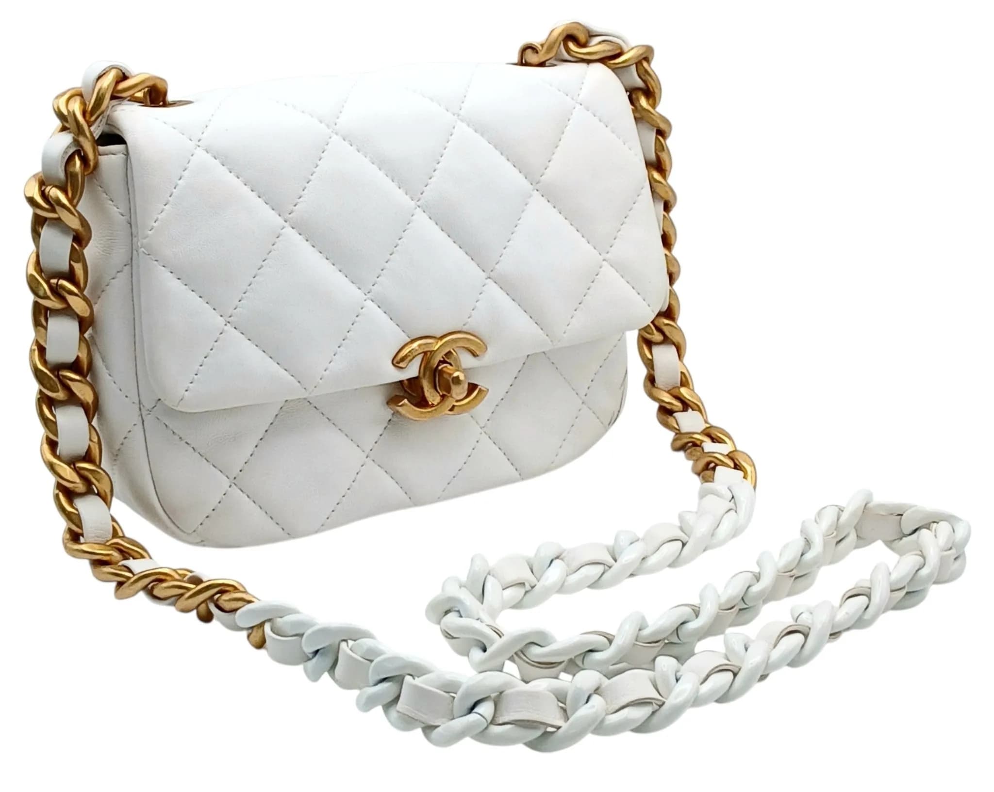 A Chanel Seasonal Flap Shoulder Bag. White quilted leather exterior with gold-tone hardware, CC turn-lock closure and chunky leather-interwoven chain shoulder strap. Black textile interior with one main compartment and an open inner side pocket. Comes with certificate of authenticity. Approx. 18.5cm length x 14.5cm height. Signs of wear, including light creasing, stains and marks to the leather exterior, rubbing to the corners and edges, and wear to the hardware. Please see photos or request a condition report. Ref: 27094.