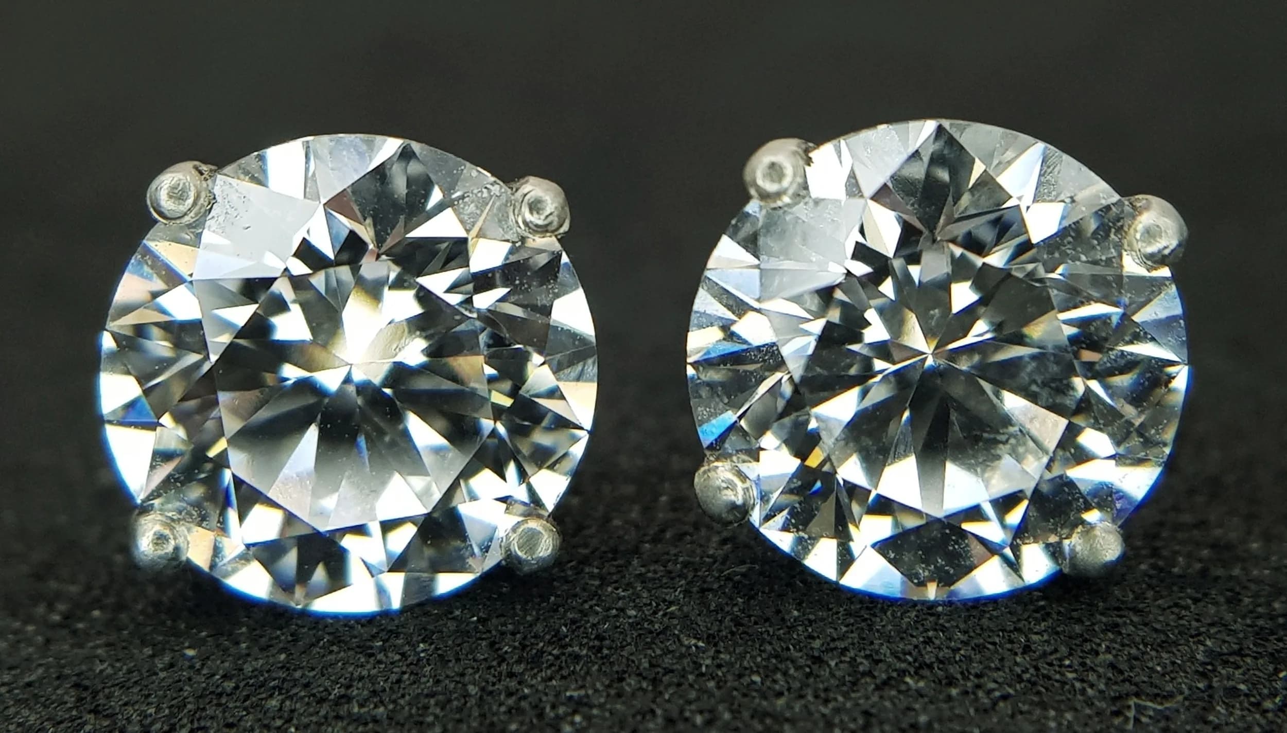 A Pair of Stunning 9K White Gold Lab-Grown Diamond Stud Earrings. 4.41ctw of round brilliant cut diamonds having F colour and VS1 clarity. Both diamonds come with their own SGL certificate. 2.15g total weight.