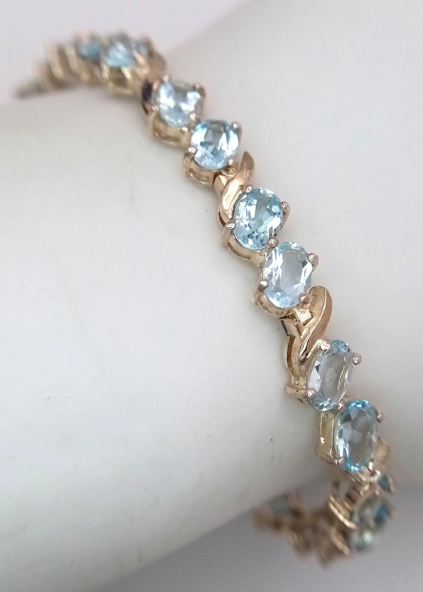 A Beautiful Sterling Silver Blue Topaz Tennis Bracelet-20cm Length. Set with Twenty-Eight 6 x 4mm Oval Cut Blue Topaz, circa 11.2 carat total. The Bracelet has a gross weight of 12.9 grams