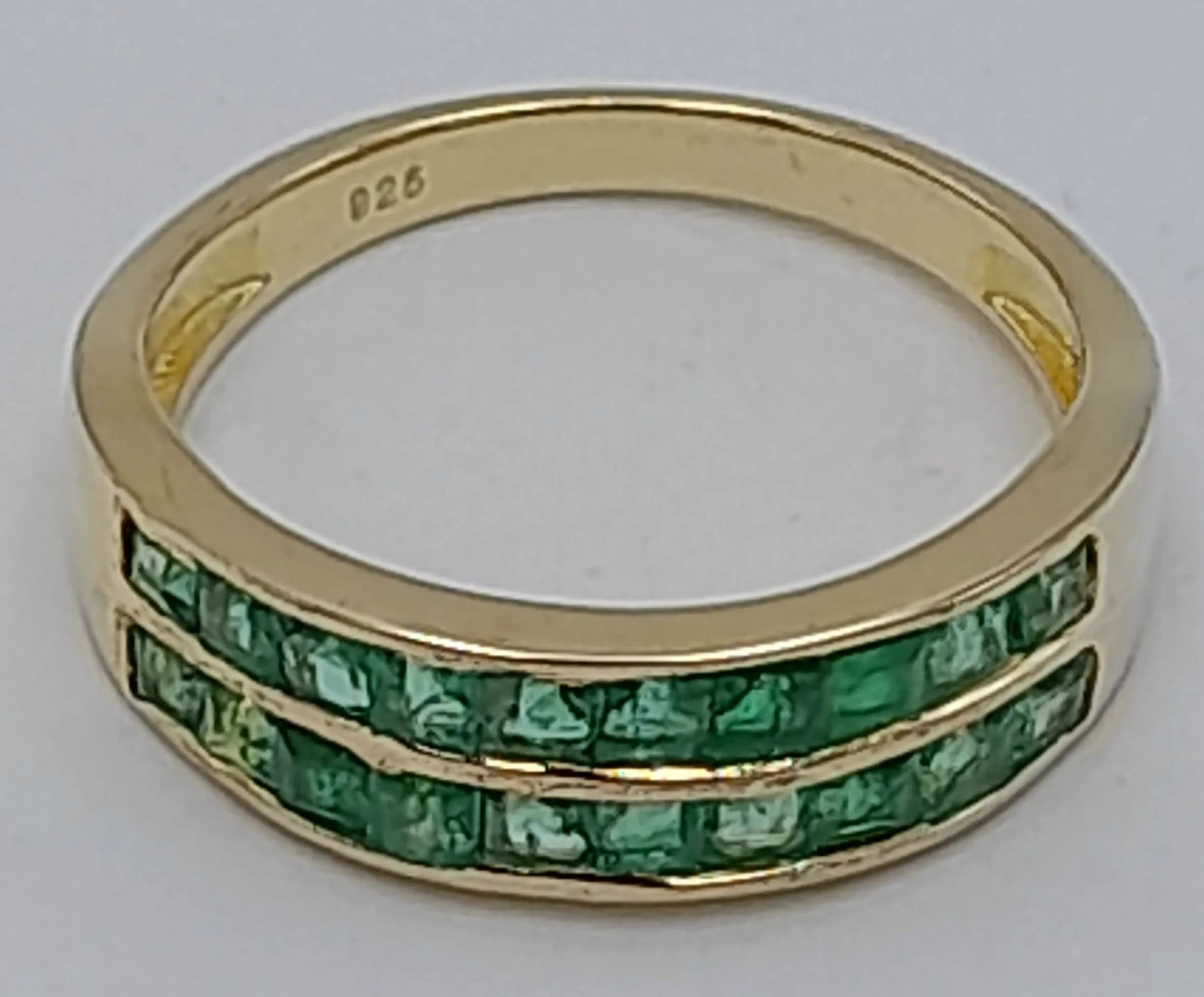 A Yellow Gold Gilded Sterling Silver Two Row Green Stone Ring Size O. The Ring measures 6mm wide at the Crown and has a gross weight of 2.39 grams.
