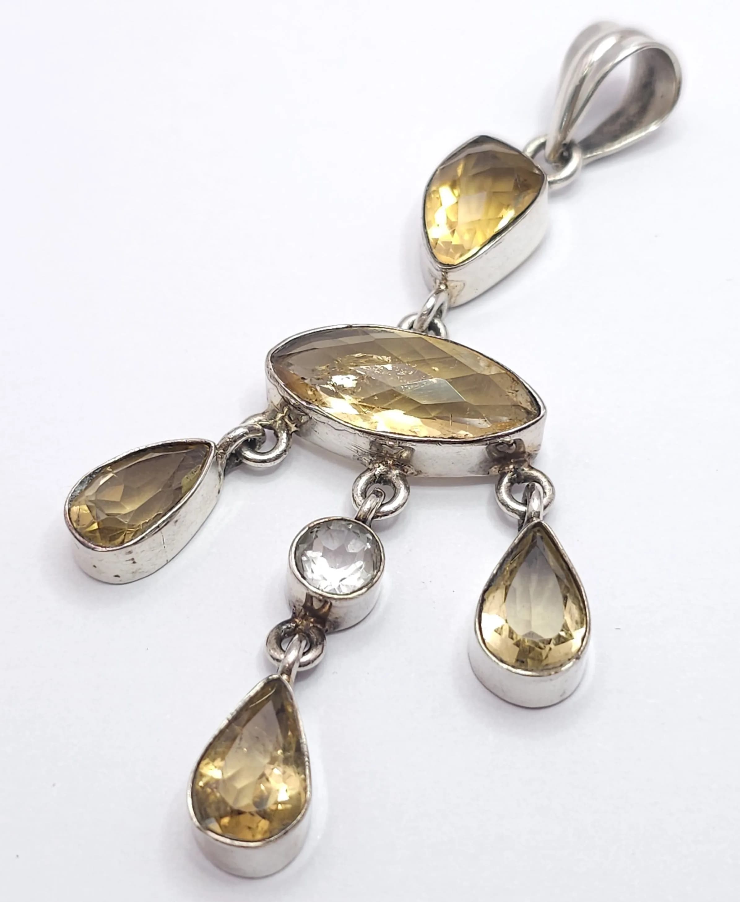 An Elegant Vintage Sterling Silver Citrine and White Quartz Chandelier Pendant. The Pendant measures 7.5cm Drop and is set with Baroque, Marquise and Tear Drop Cut Citrine with a Centre Round Cut White Quartz. The Pendant has a gross weight of 14.48 grams.