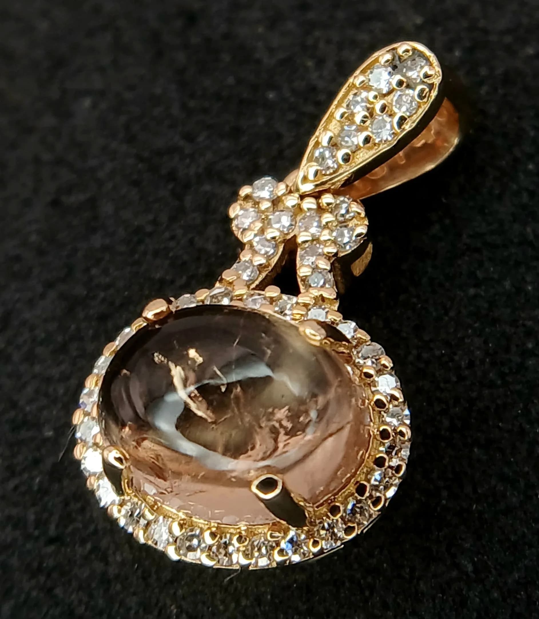 A 14K Gold, Tourmaline and Diamond Pendant. A 1.6ct oval cabochon with a 43 diamond surround of 0.13ctw. 2cm. 1.47g total weight. Comes with an HRD Antwerp certificate. Ref: CLP-10740.