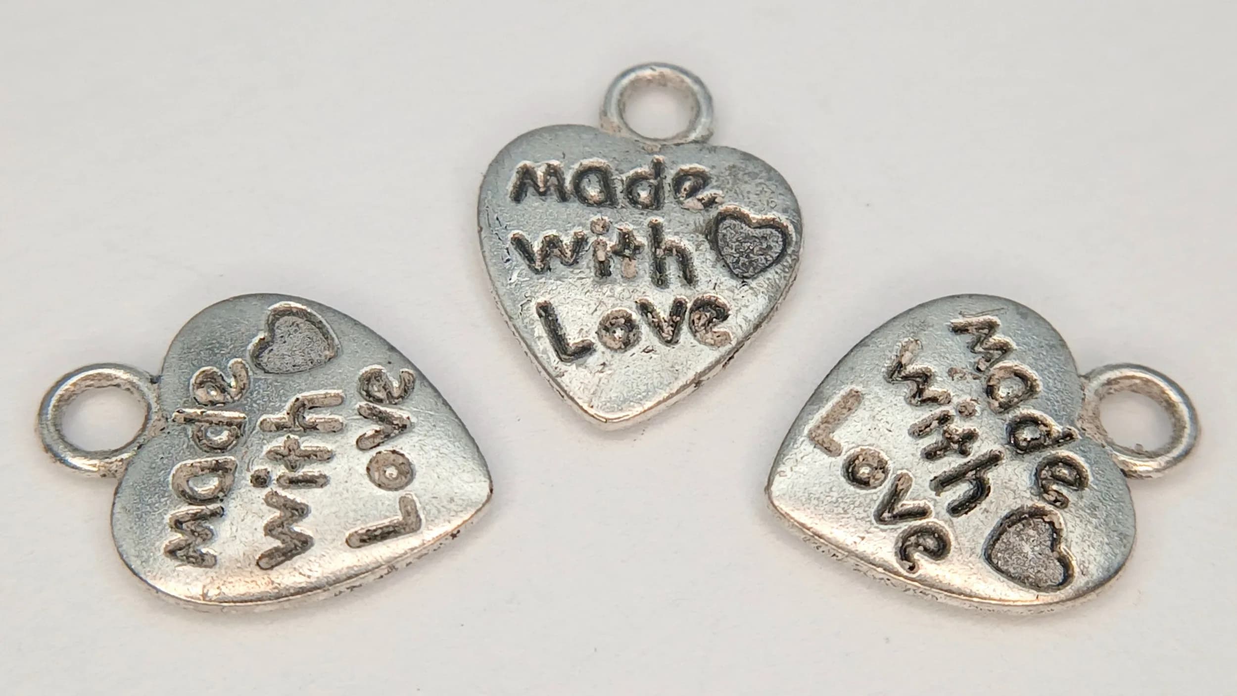 A COLLECTION OF 3, STERLING SILVER, HEART CHARMS / PENDANTS. ALL ENGRAVED WITH THE WORDS MADE WITH LOVE ON BOTH SIDES. 1.3G. SC 7100
