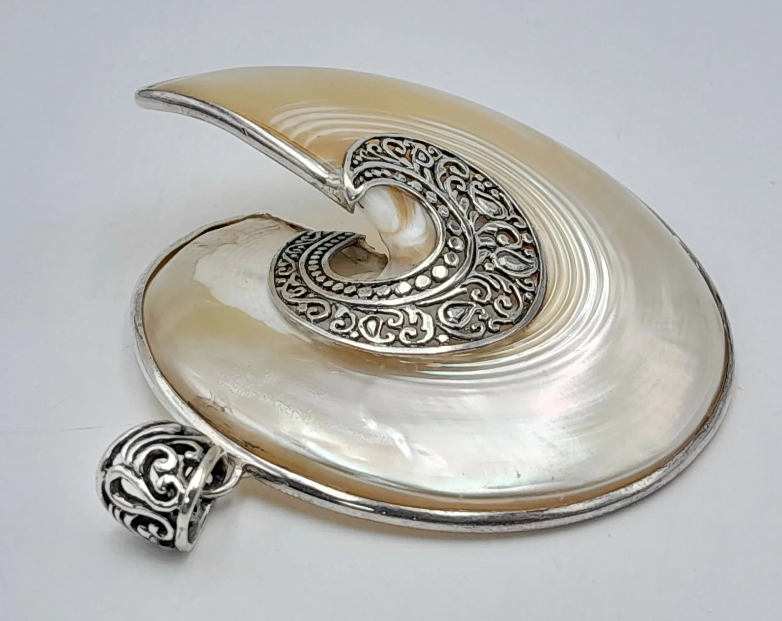 An Artisan Balinese Sterling Silver and Mother of Pearl Nautilus Swirl Pendant. 6cm Width. Gross weight 18.16 grams.