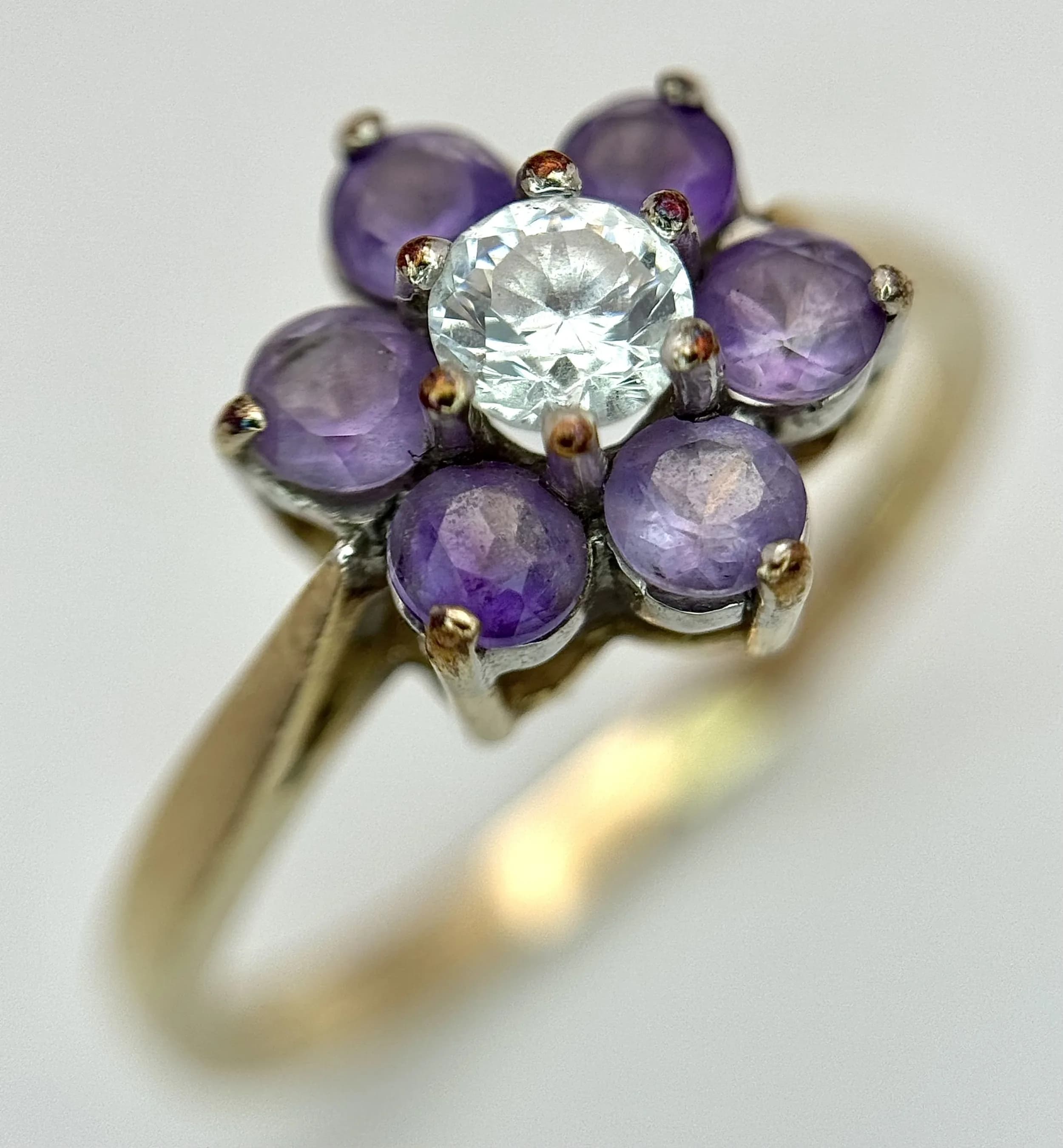 A 9K Yellow Gold, Amethyst and White Stone Ring in Floral Form. Size P. 2.35g.