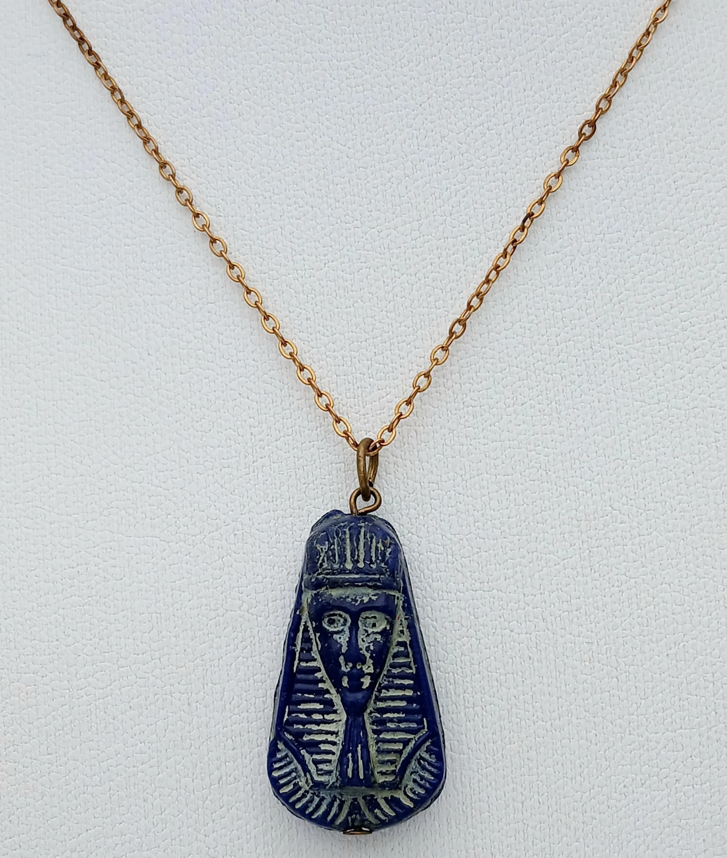 A Vintage Rolled Gold and Blue Pressed Glass Egyptian Pendant Necklace. 46cm Length Rolled Gold Chain. The Pendant measures a 2.5cm drop and the Necklace has a gross weight of 4.5 grams.