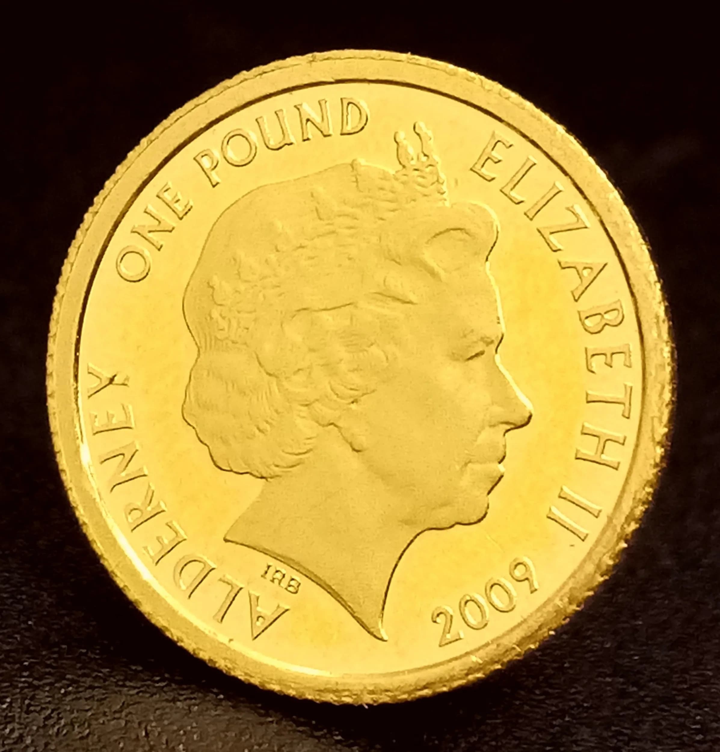 A 2009, QUEEN ELIZABETH II, 24K FINE GOLD COIN. ALDERNEY, 50TH ANNIVERSARY OF THE FIRST MINI CAR. 22K GOLD. 1.2G. C7008.