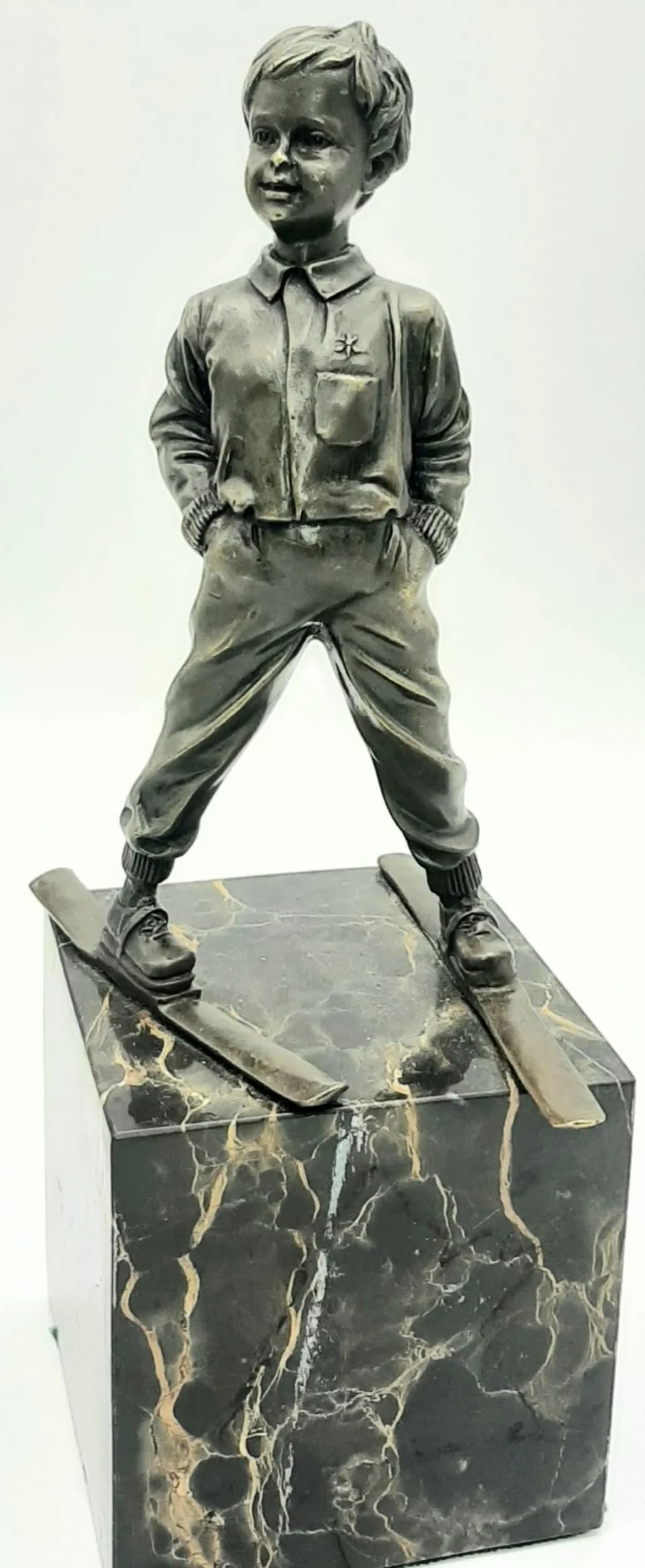 A VINTAGE BRONZE SCULPTURE OF A BOY ON SKIS MOUNTED ON A SOLID MARBLE BASE. 28cms TALL AND 3.2kg. Winning bidder must collect from Cadmore HQ or arrange a courier service.
