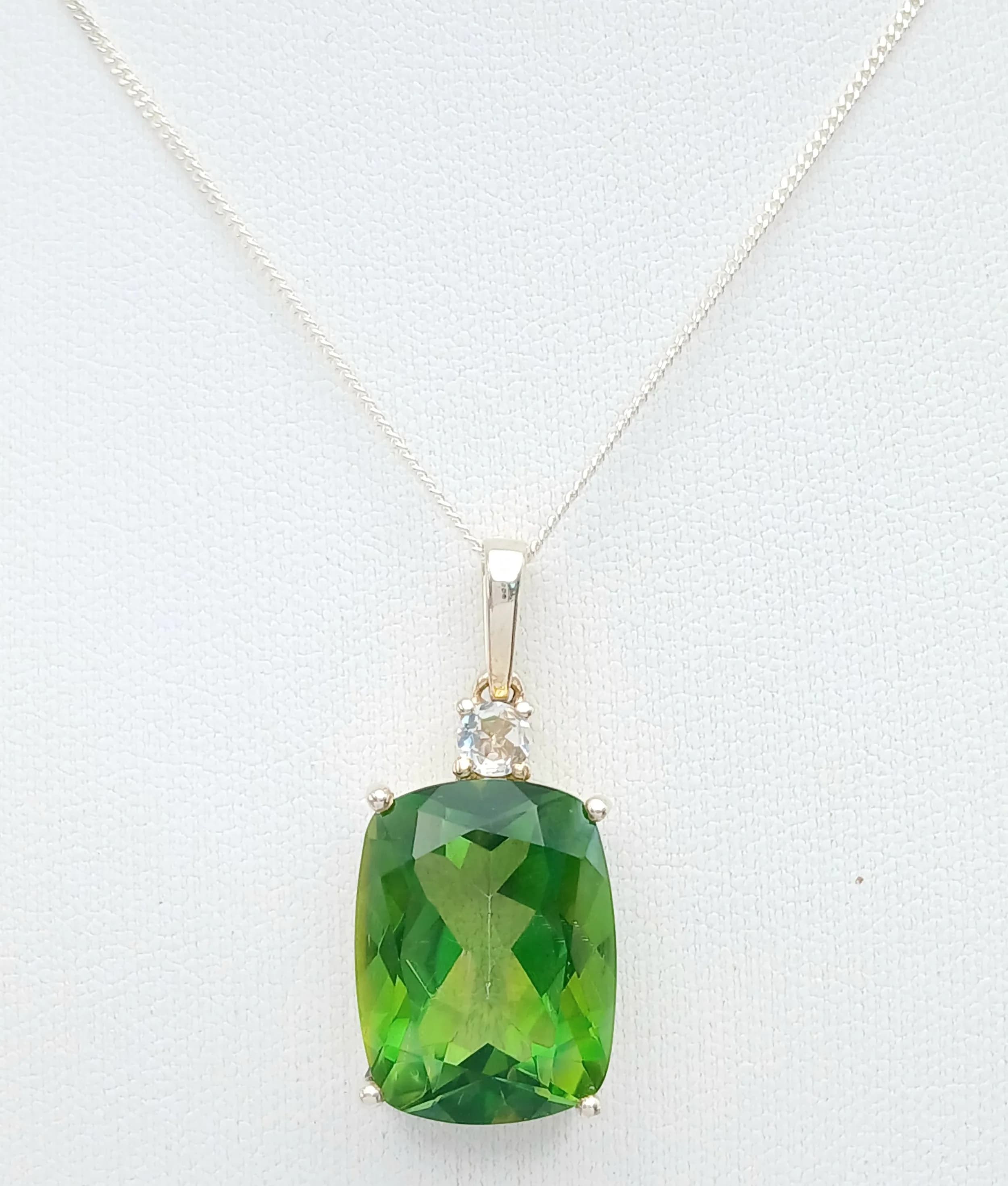 An Attractive Sterling Silver Peridot and White Topaz Pendant Necklace-46cm Length Chain. The Pendant measures a 3cm Drop and is set with a large 18 x 14mm Cushion Cut Peridot, approximately 12.5-15 carat and with a 3mm Round Cut White Topaz Set above. The Necklace has a gross weight of 7.97 grams