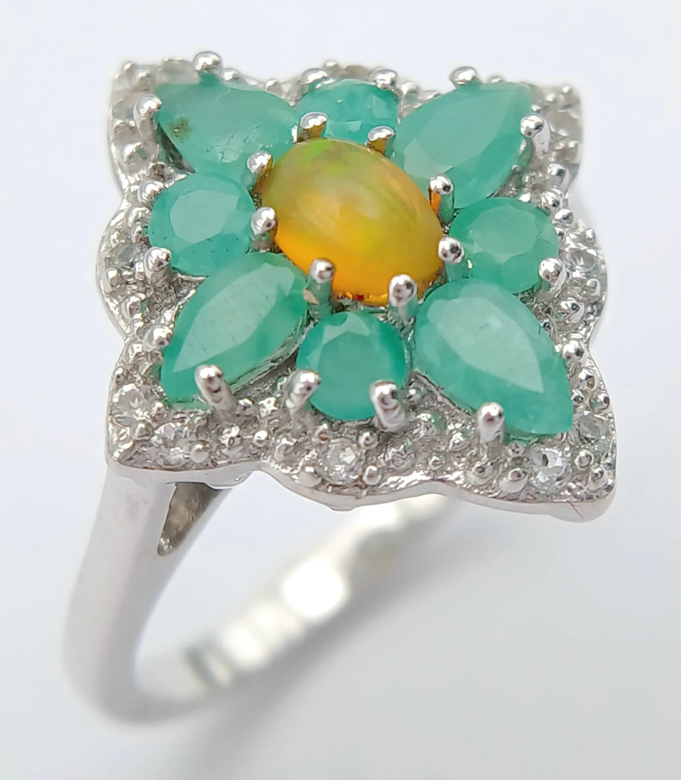 A Beautiful Sterling Silver Opal, Emerald and White Spinel Ring Size R1/2. The Crown measures 2 x 1.8cm. Gross Weight 4.27 grams.