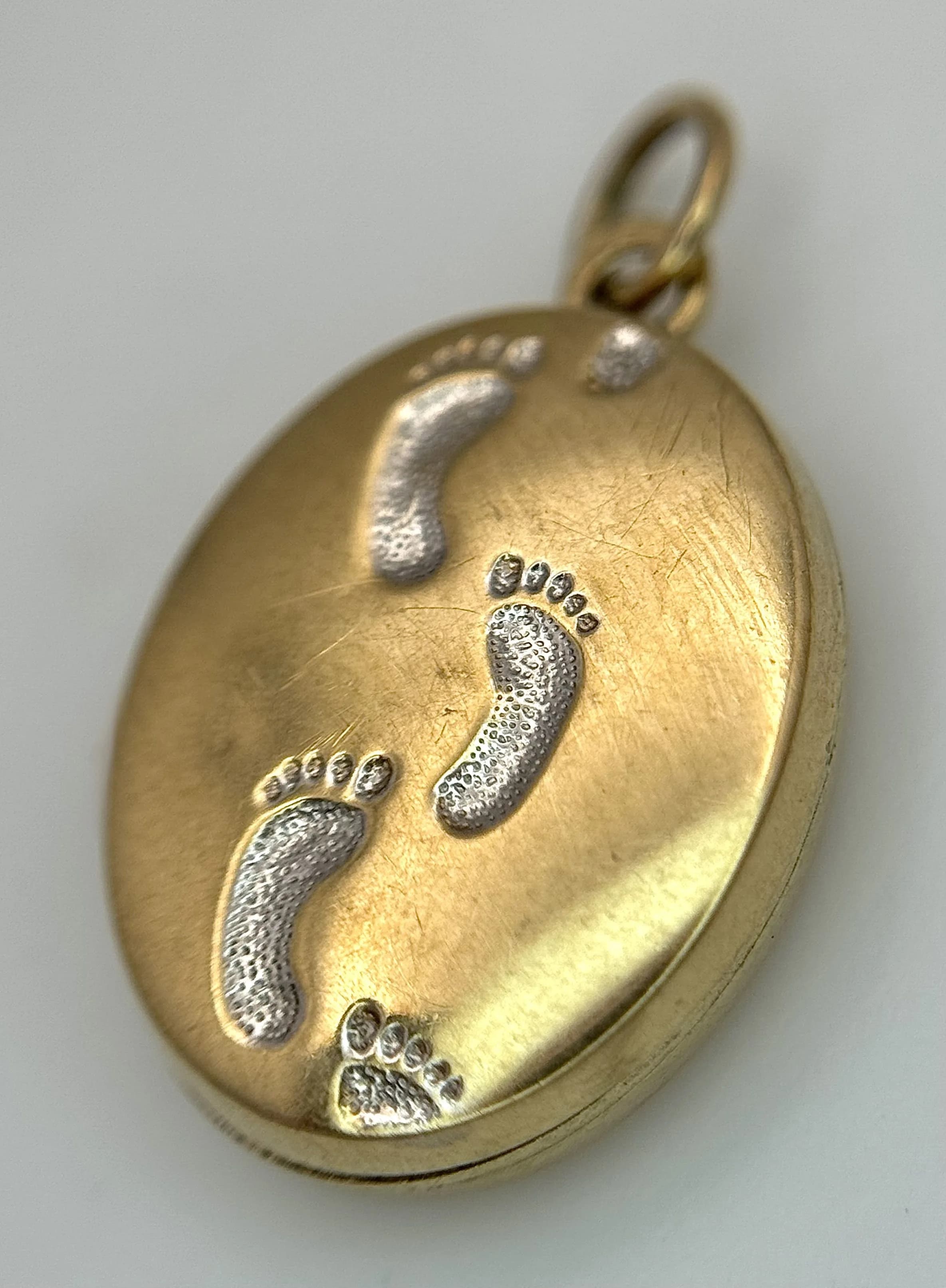 A 9K YELLOW GOLD, FOOTPRINTS, OVAL LOCKET PENDANT. ENGRAVED WITH THE WORDS, WHEN YOU SAW ONE SET OF FOOTPRINTS, IT WAS THEN THAT I CARRIED YOU. 1.1G. SC 7027