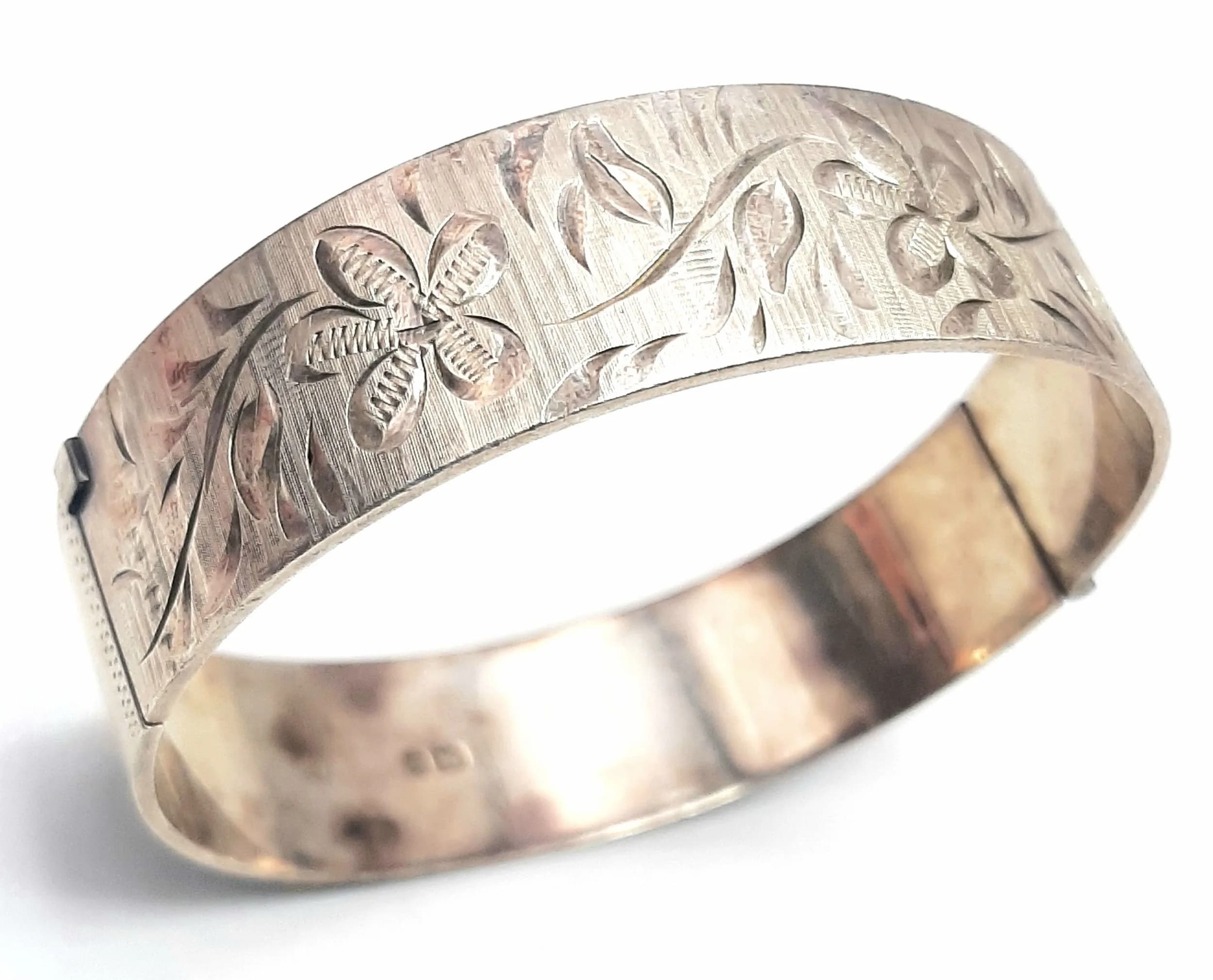 A Silver Engraved Cuff Bangle. Open cuff form with engraved floral and foliate decoration. Hallmarked Birmingham 1979. Approx 17.5cm circumference. Total weight 36.4 grams.