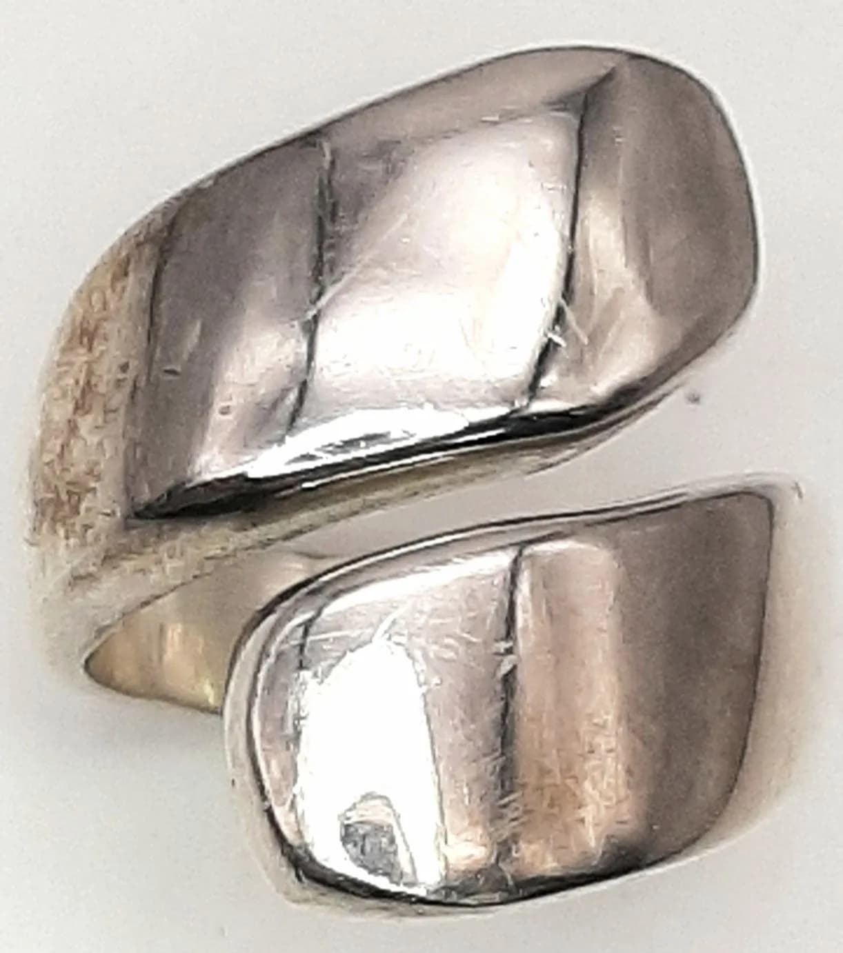 A 925 Silver Wraparound Ring. Polished wraparound design with curved overlapping panels. Hallmarked 925. Ring size P. Total weight 13.10 grams.