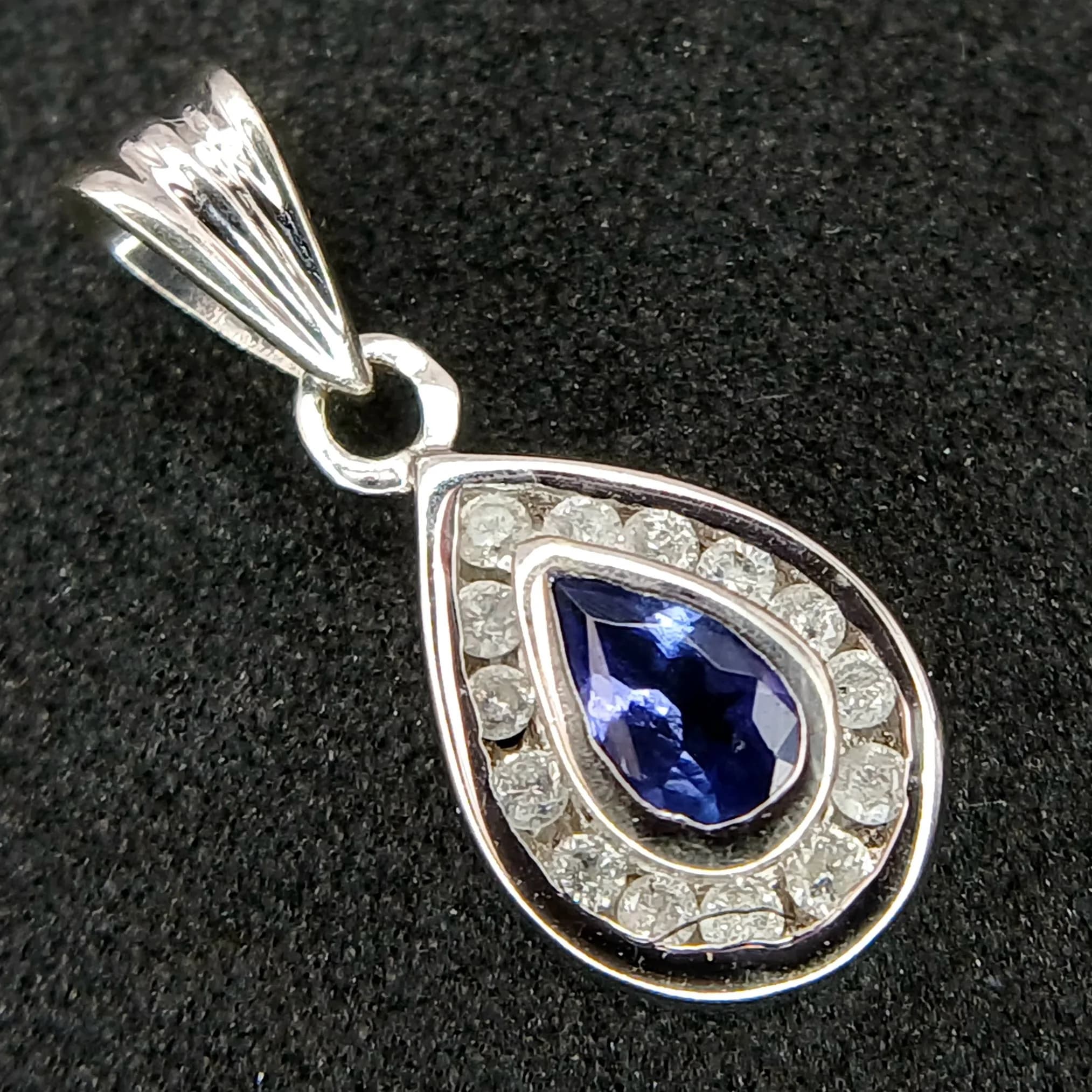 A 9K WHITE GOLD, DIAMOND AND IOLITE SET, PEAR SHAPED PENDANT. 1G. TAN 7009