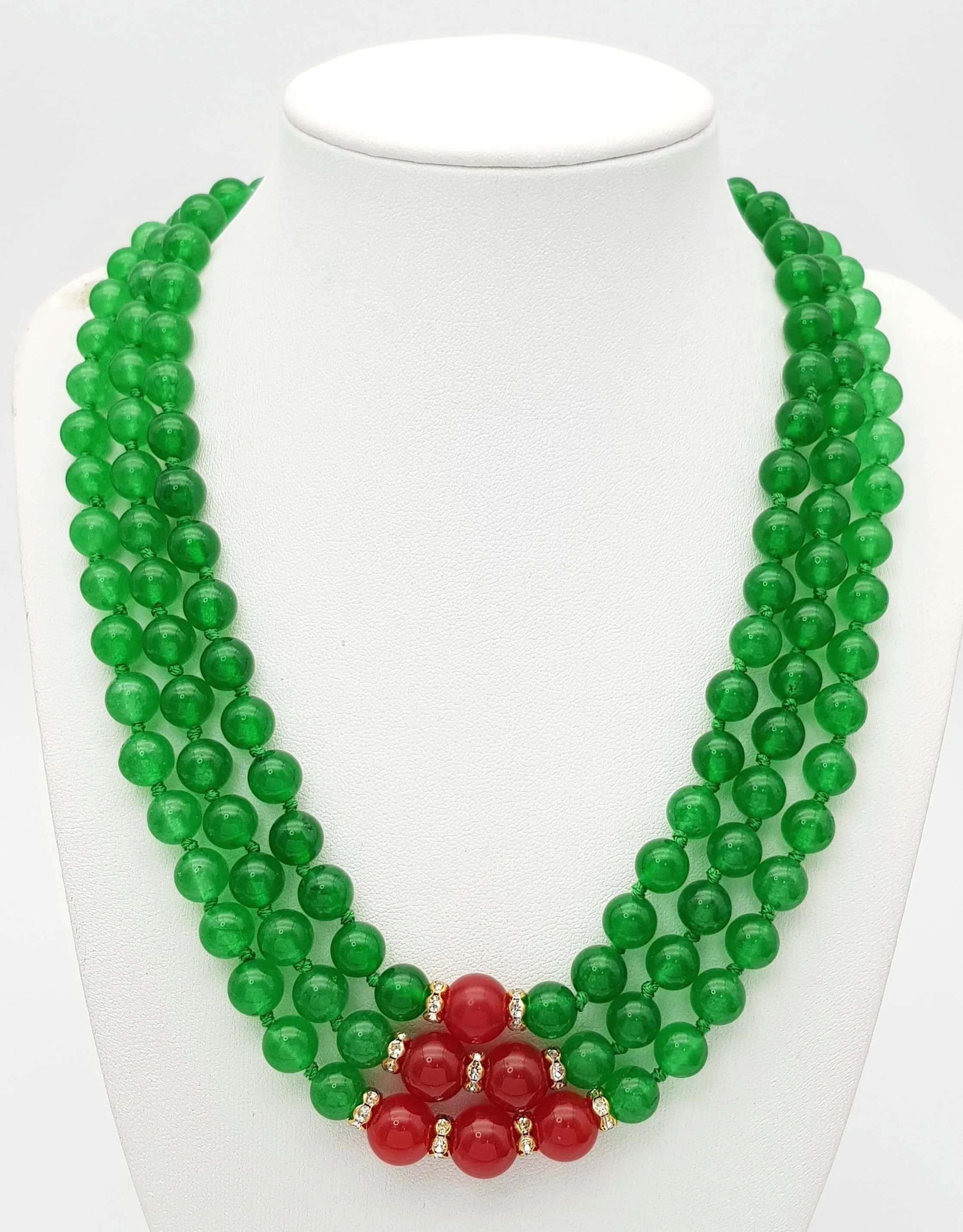 A Green and Red Jade Three Row Necklace. 8mm green jade. 10mm red jade. 42-46cm necklace length.