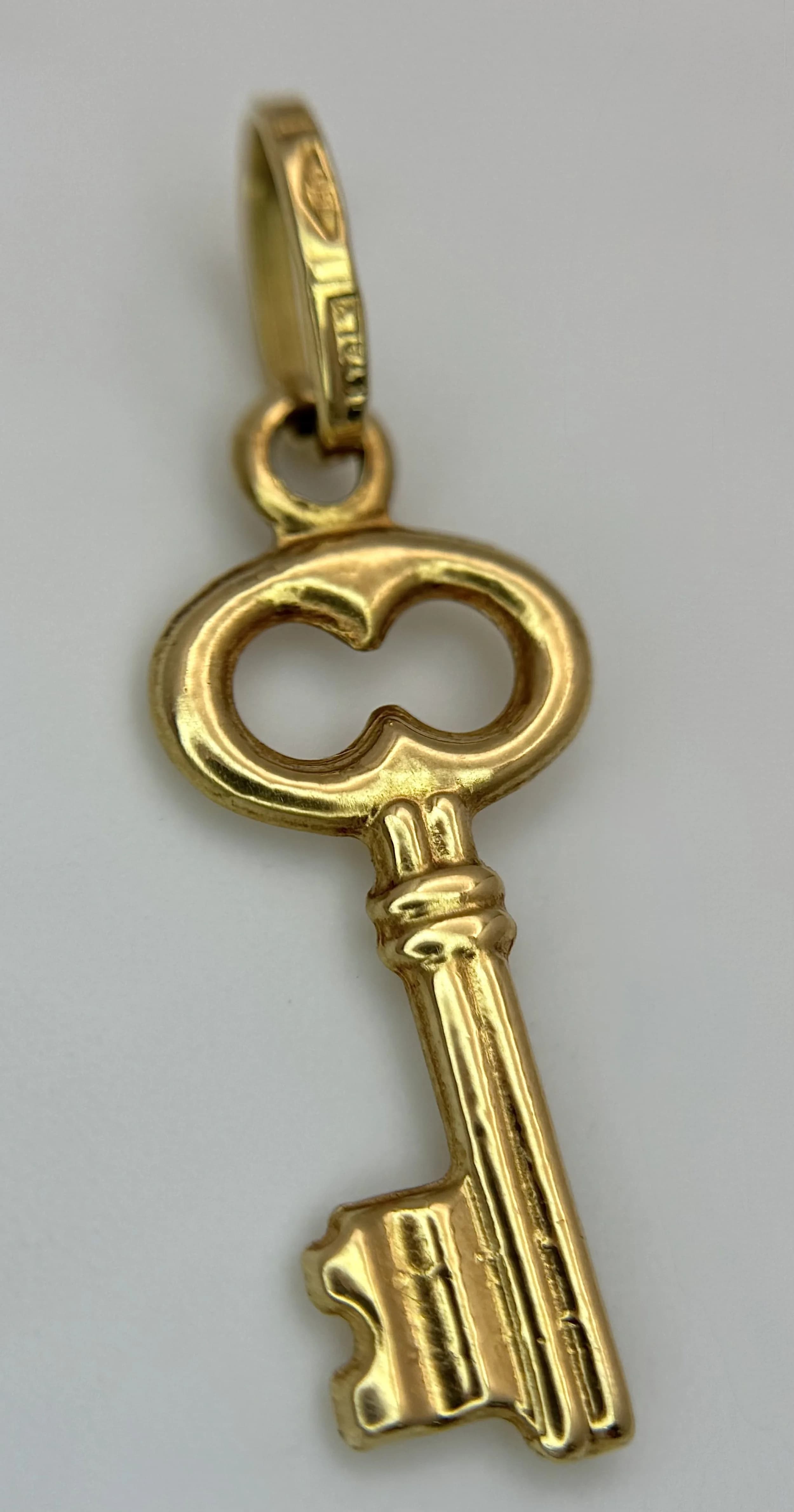 AN 18K YELLOW GOLD, KEY CHARM / PENDANT. 0.7G. SC 7079