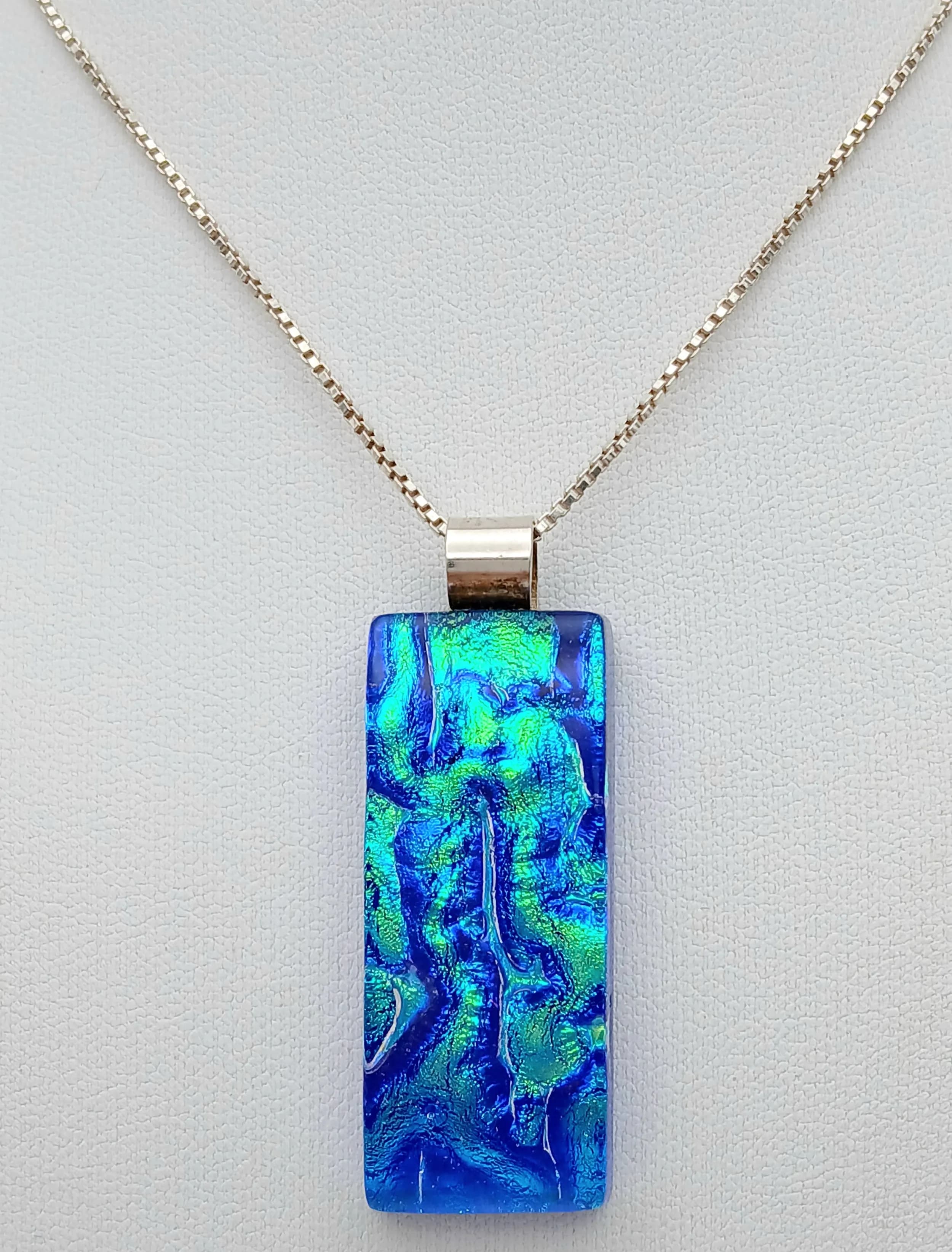 A Vintage Sterling Silver Peacock Blue Glass Pendant Necklace. 43cm Length Chain. The Pendant measures 4.7 x 1.7cm and the Necklace has a gross weight of 17.29 grams.