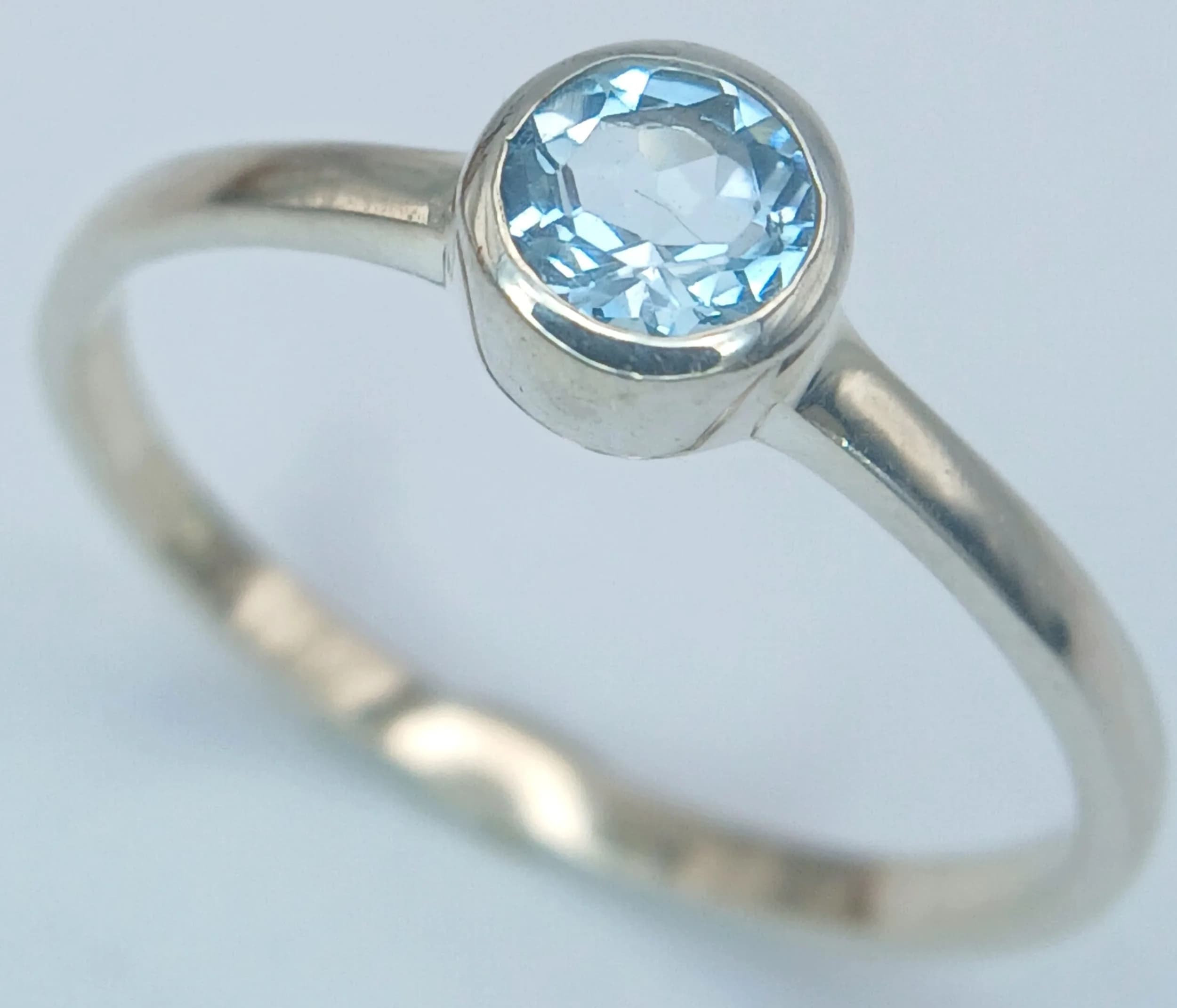 A Sterling Silver and Blue Topaz Solitaire Ring Size P. The Ring is set with a 4mm Round Cut Blue Topaz, approximately 0.50 carat. The Ring weighs 1.44 grams.