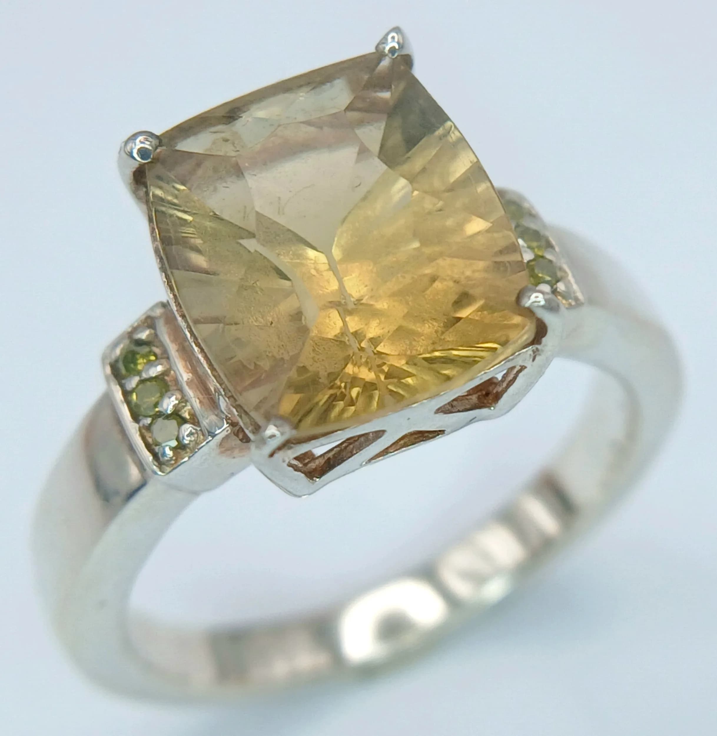 A Sterling Silver Citrine Set Ring Size O. Appears practically unworn if worn at all. Set with an 11 x 9mm Rectangle Cushion Cut Citrine, approximately 3.3 carat and with Six Round Cut Citrine to the Sides. Gross weight 5.03 grams.