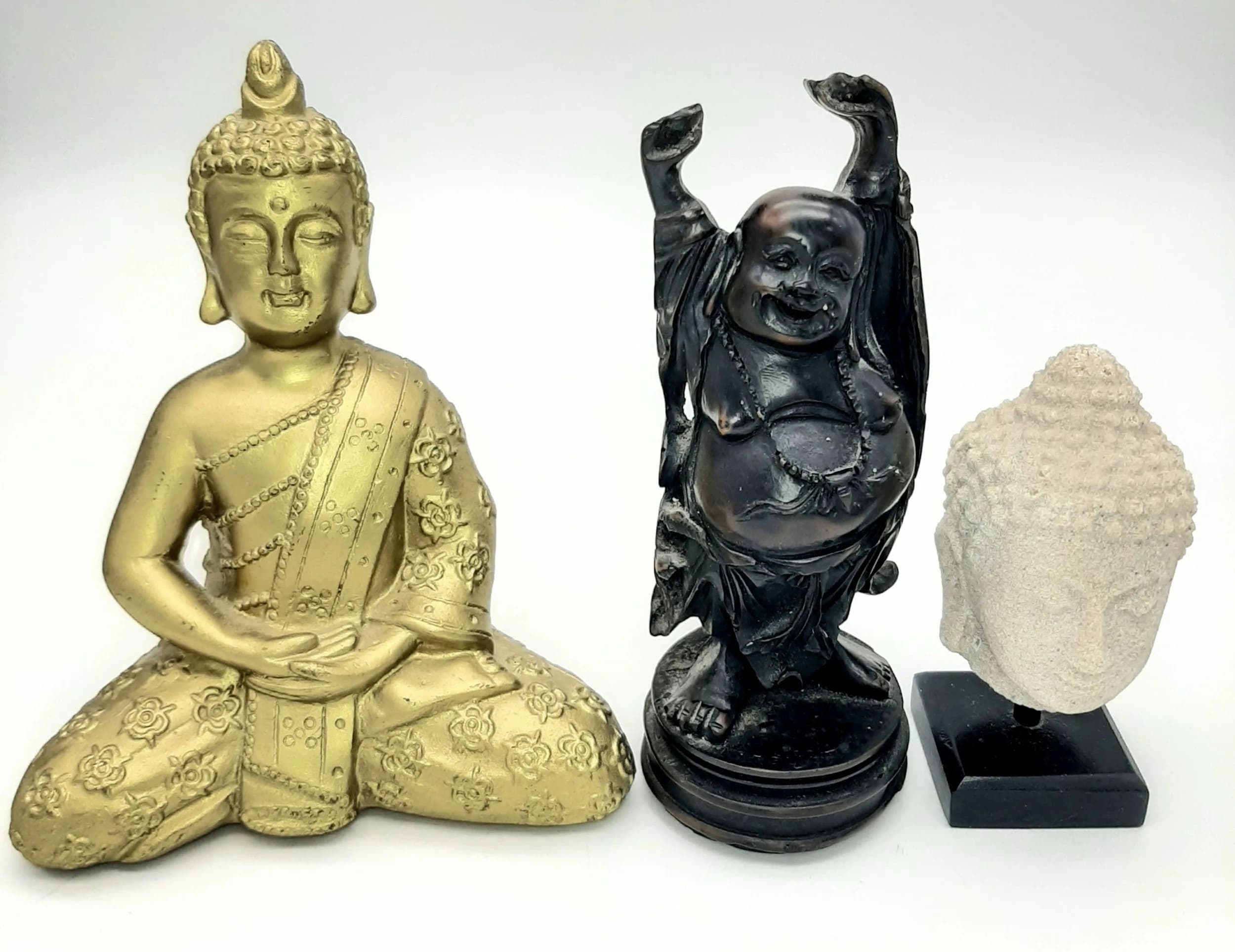 A Collection of Three Buddhas.. Comprising 1) A Vintage Hand Carved Hard Wood Buddha 15cm Tall, 2) A Reconstituted Stone Buddha Head on Wooden Plynth.10cm Tall and 3) A Later Gold Tone Resin Seated Figure. 16cm Tall.
