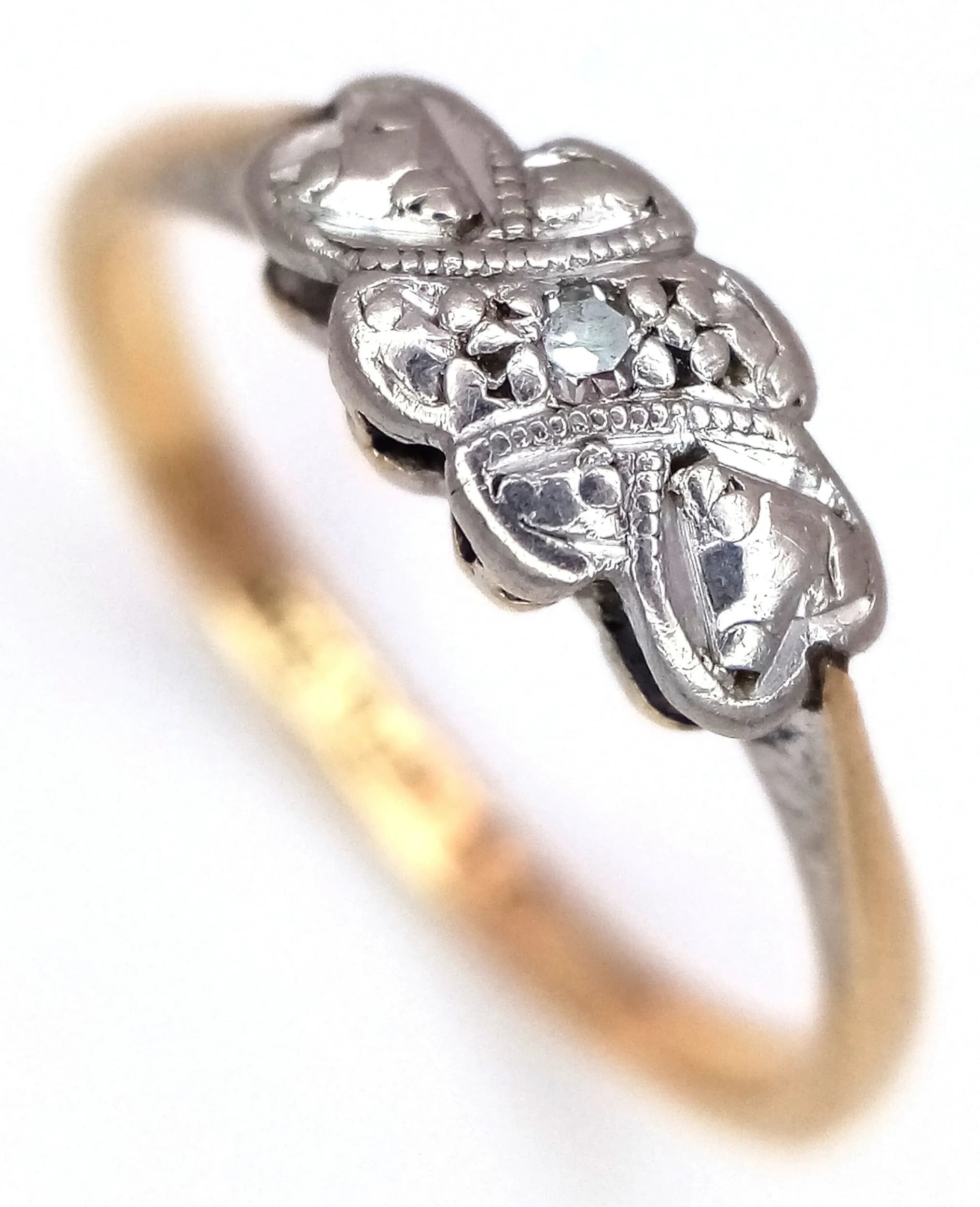 A 9k Yellow Gold and Platinum Art Deco Design Diamond Ring Size M. The Ring is set with a 0.10 carat round old cut Diamond. The Ring measures 5mm wide at the crown and has a gross weight of 1.82 grams.