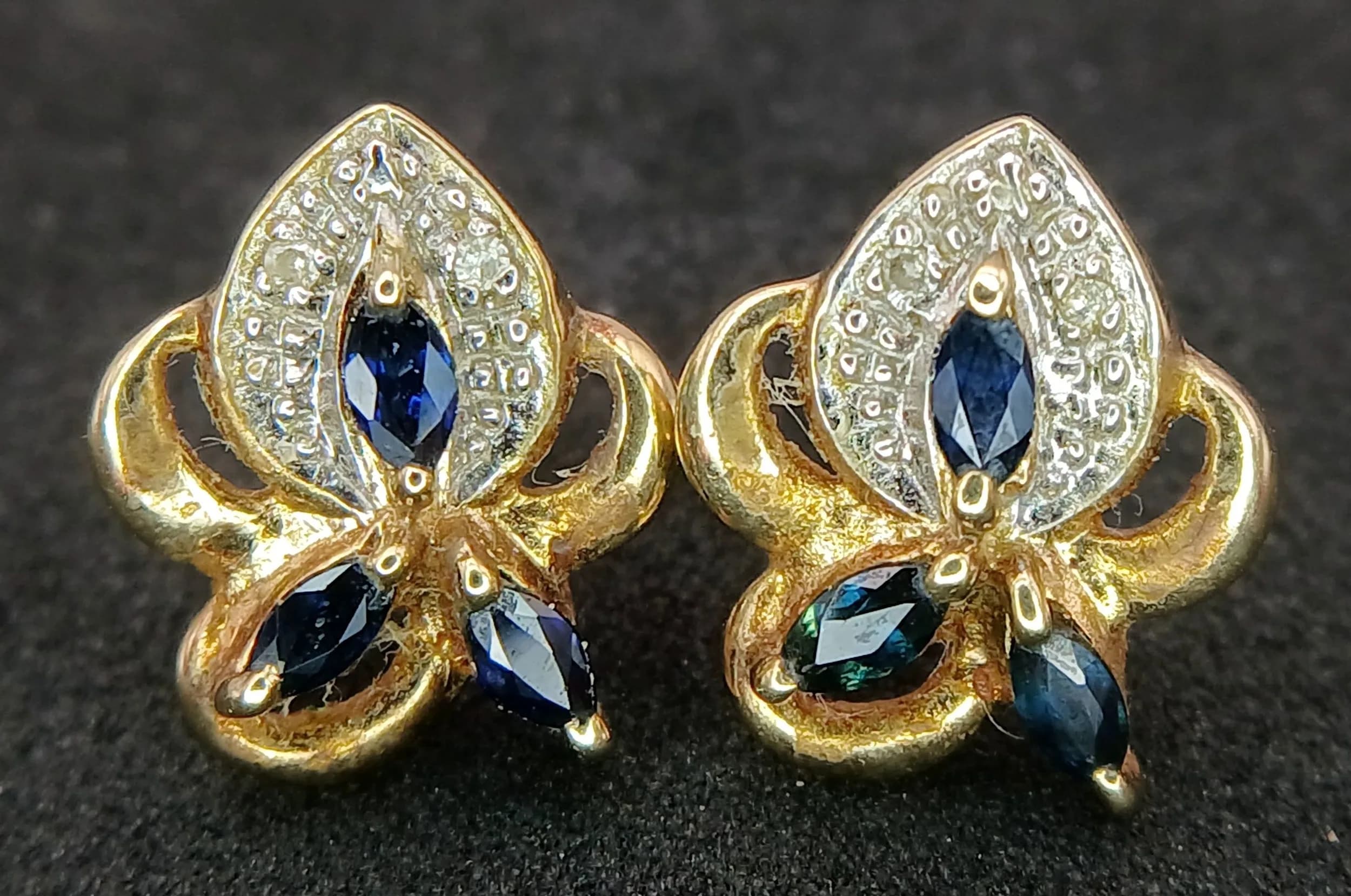 A Stylish Pair of 9k Yellow Gold Blue Spinel and Diamond Stud Earrings. 1.4 x 1.2cm. Combined Gross Weight 2.04 grams.
