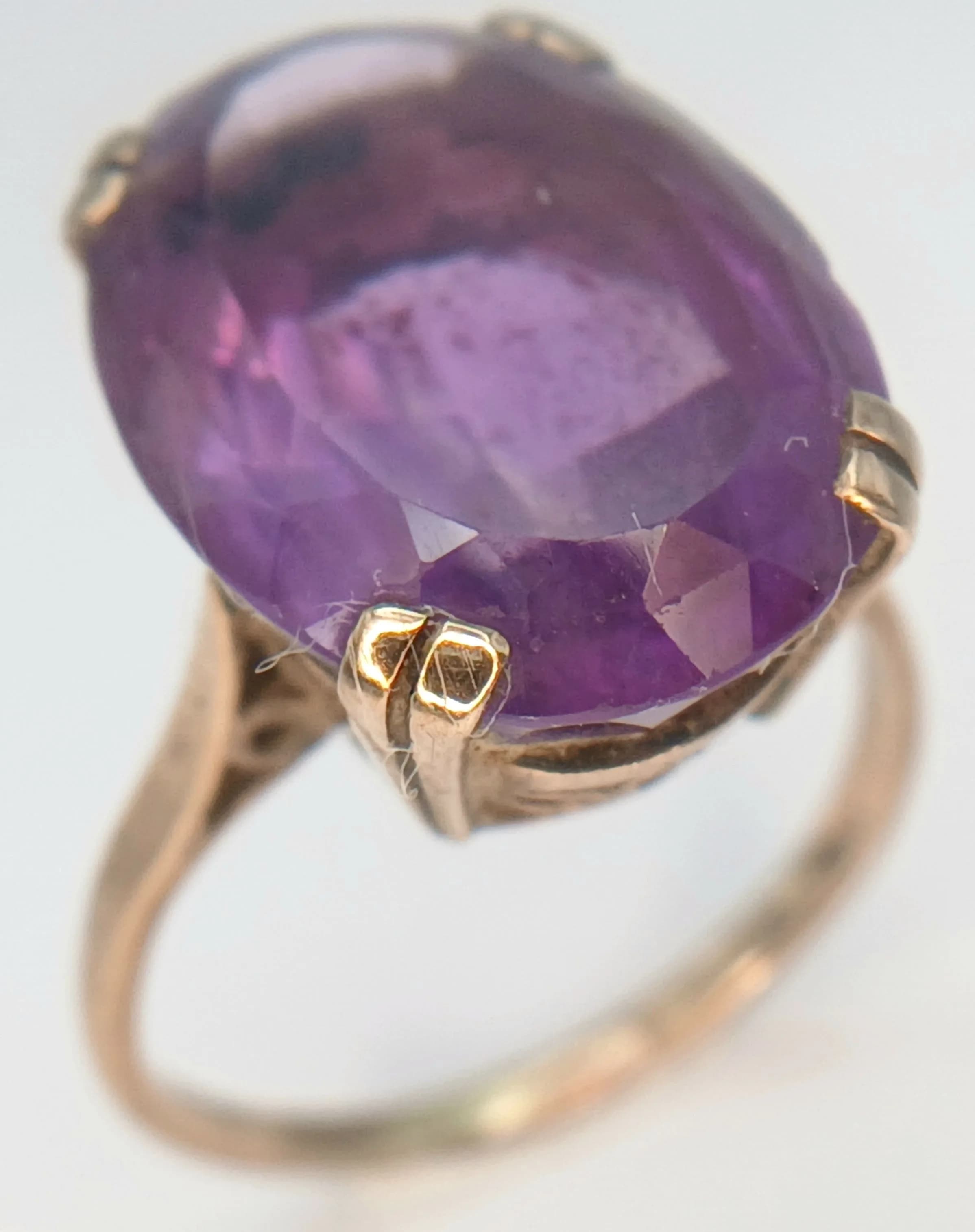 A 9K Yellow Gold and Amethyst Cocktail Ring. 10ct oval cut amethyst. Size L. 4g total weight.