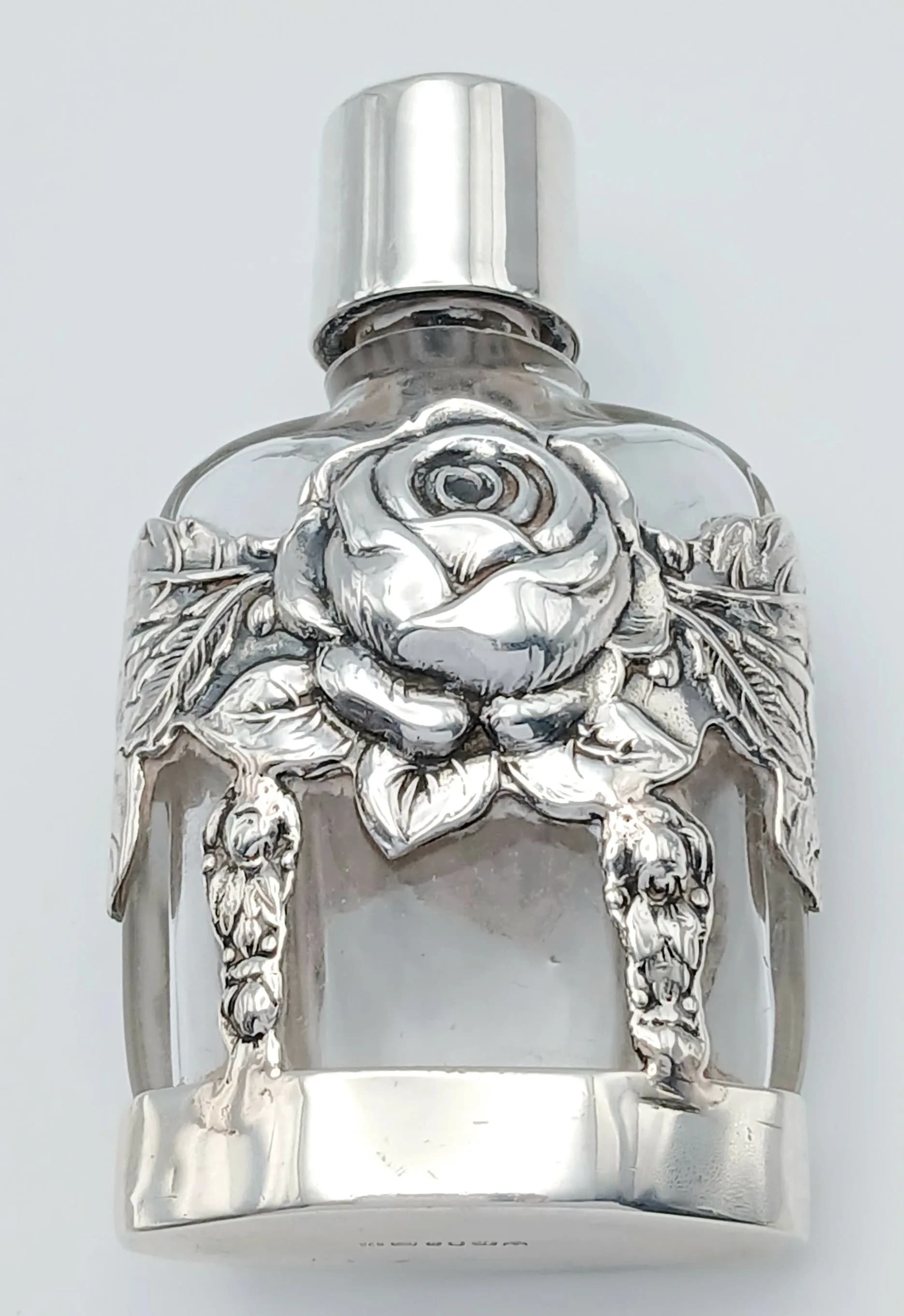 A Glass and Sterling Silver Small Scent Bottle. Silver base and decorative floral body. London hallmarks. 6.5cm.