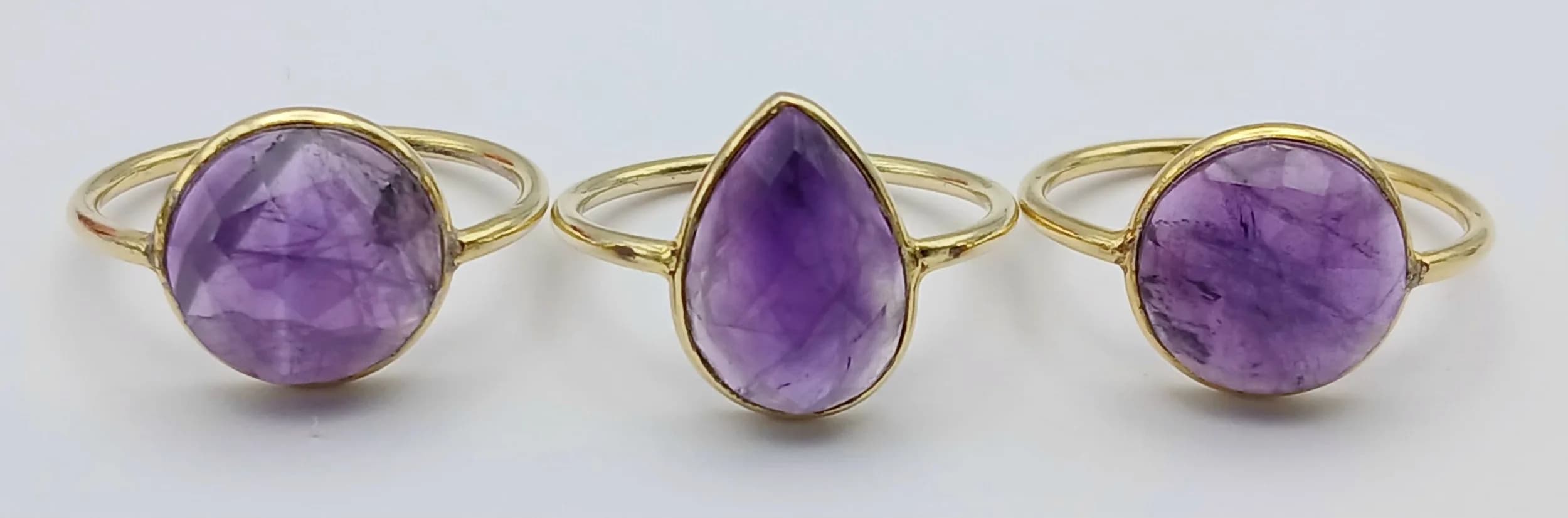 A Parcel of Three Vintage Gold Gilded Sterling Silver Amethyst Set Ring Sizes P (Pear Cut), P1/2 (Round Cut) P (Round Cut). All set with faceted Amethysts measuring 11mm Diameter (Round Cut) and 13 x 9mm (Pear Cut). Combined gross weight 5.74 grams .