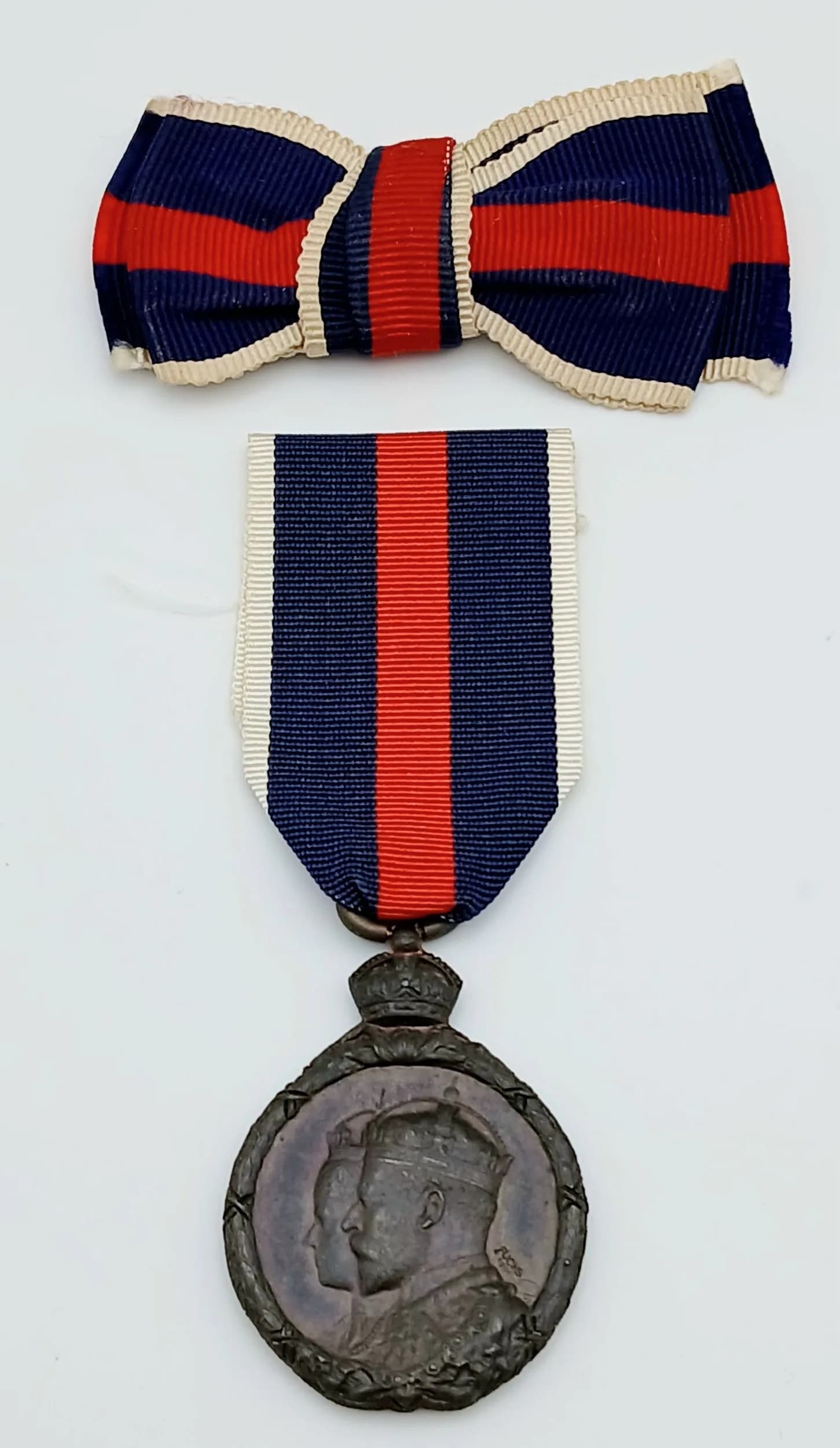 An Edward VII Coronation Medal in bronze. Un-named as issued. Together with an additional ribbon bow for wear by a lady. Good Very Fine (GVF) condition.