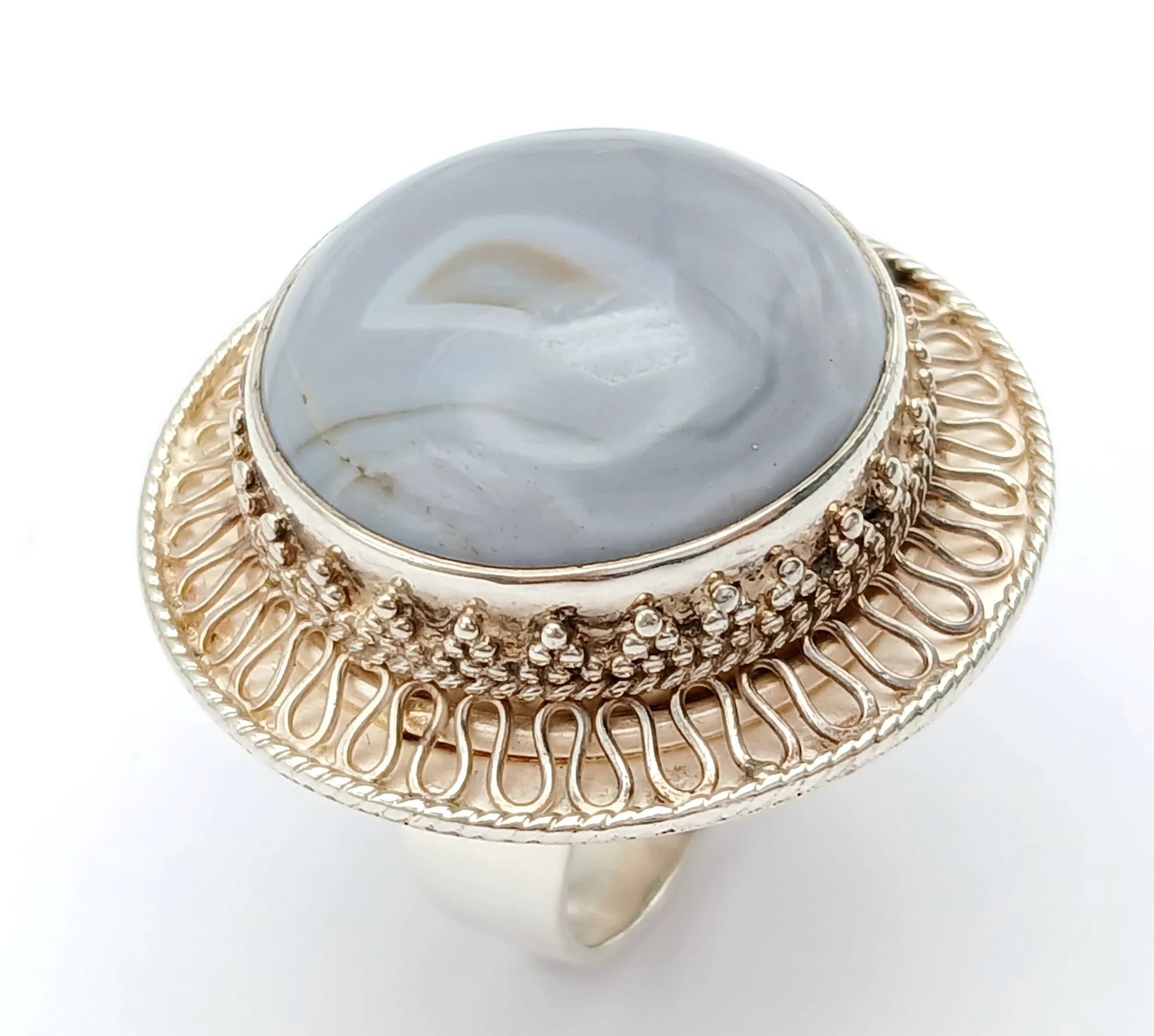 An Impressive Sterling Silver and Blue Lace Agate Set Ring Size M. The Ring is set with a 2cm Round Cut Blue Lace Agate making up a crown size of 3cm diameter. Gross weight 14.29 grams.