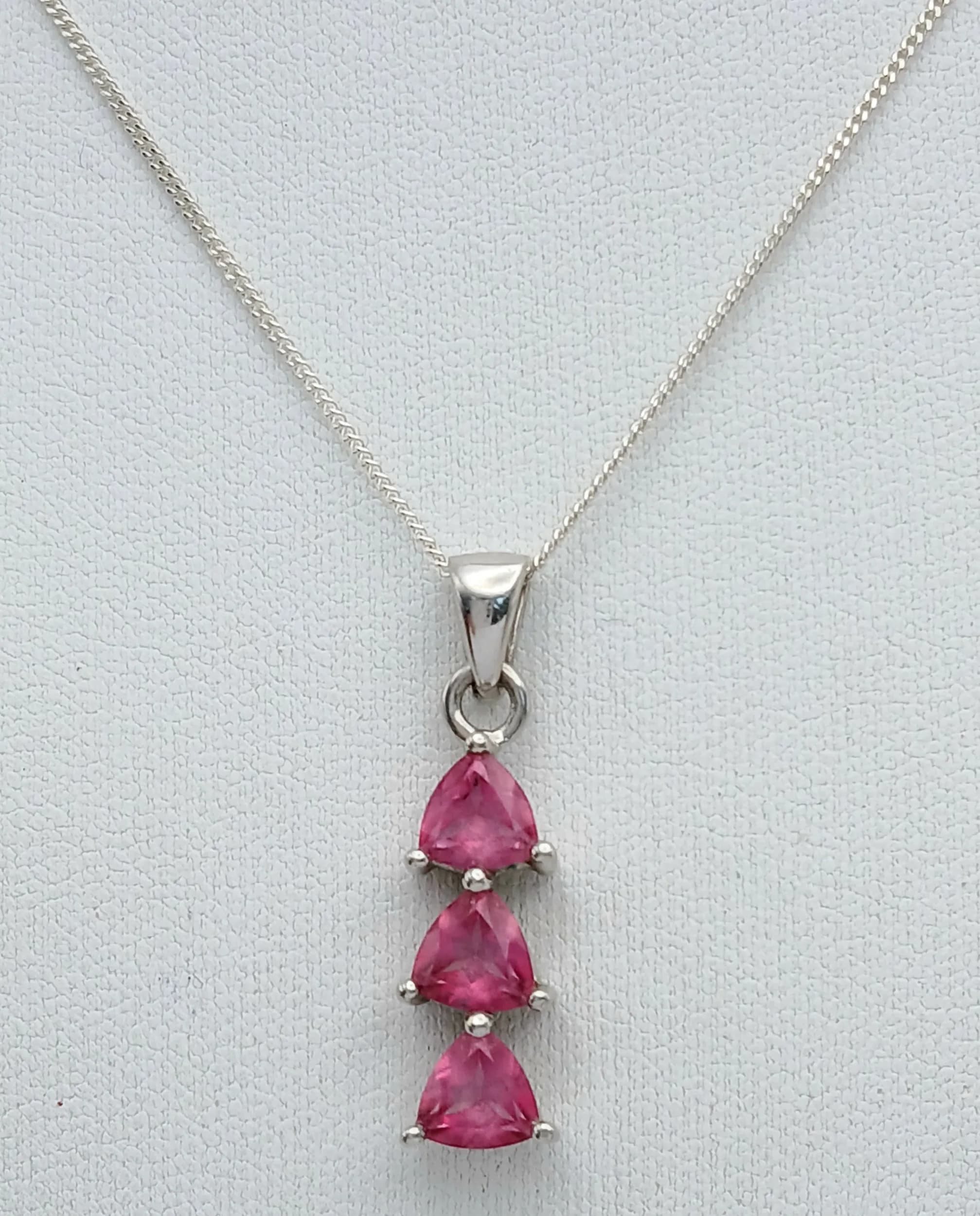 A Sterling Silver and Pink Topaz Trilogy Necklace. 46cm Length Chain. The Pendant is set with Three 5mm Trillion Cut Pink Topaz, approximately 1.5 carat total. Gross Weight 3.87 grams.