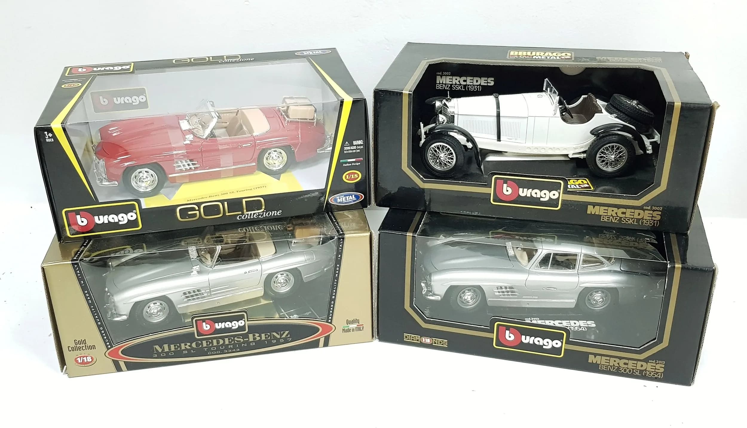 Four 1/18th scale die cast Mercedes cars by Burago. Good condition with some slight wear to boxes from storage.