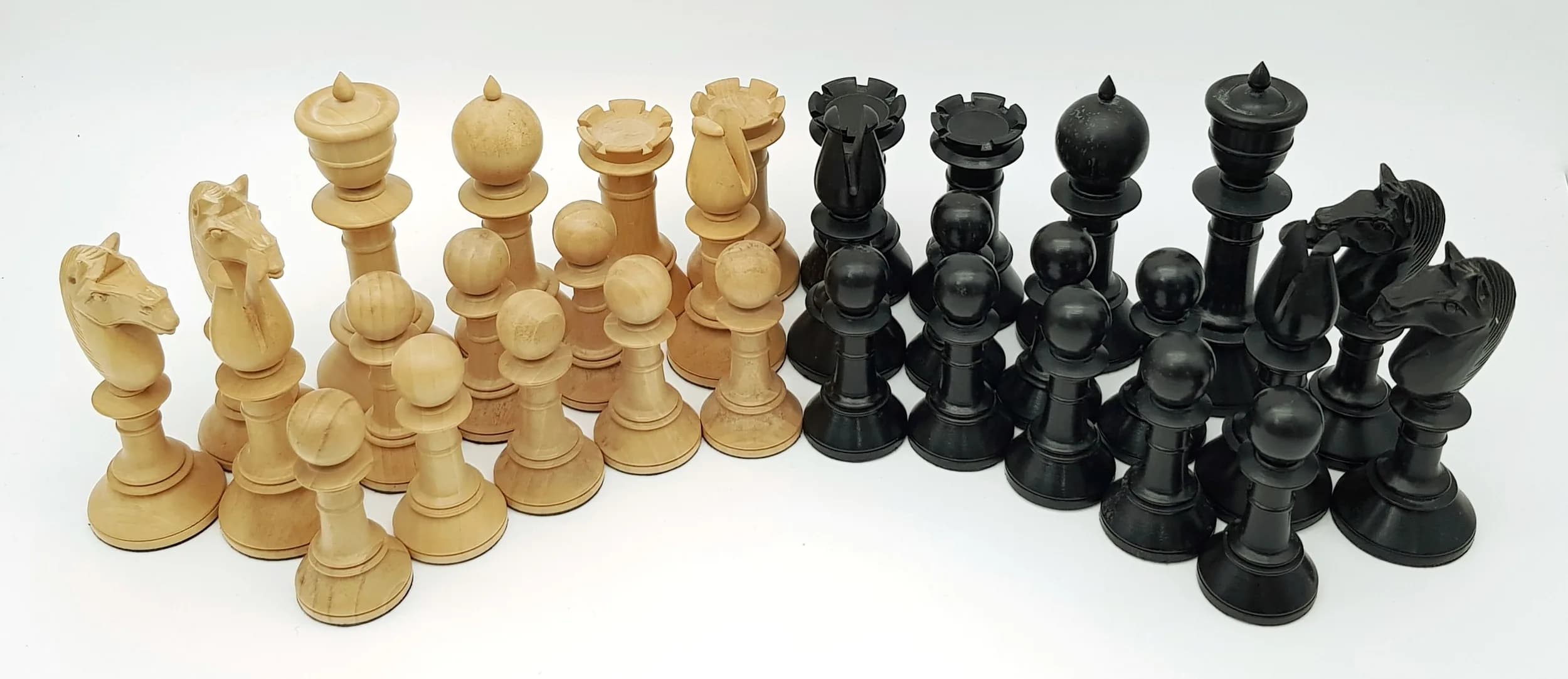 A Weighted Arabic Style Boxwood and Ebony Chess Piece Set. Approximately 4.25" King height. Slight damage on Queens. Comes in a whitewood chest.