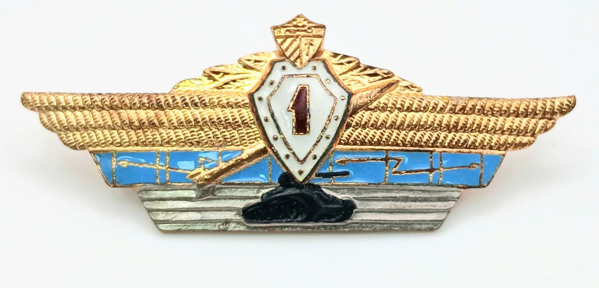 A Soviet Officer Class I Qualification Badge. Gilt metal badge with enamel decoration and winged design. Circa 1980s. Comes with box.