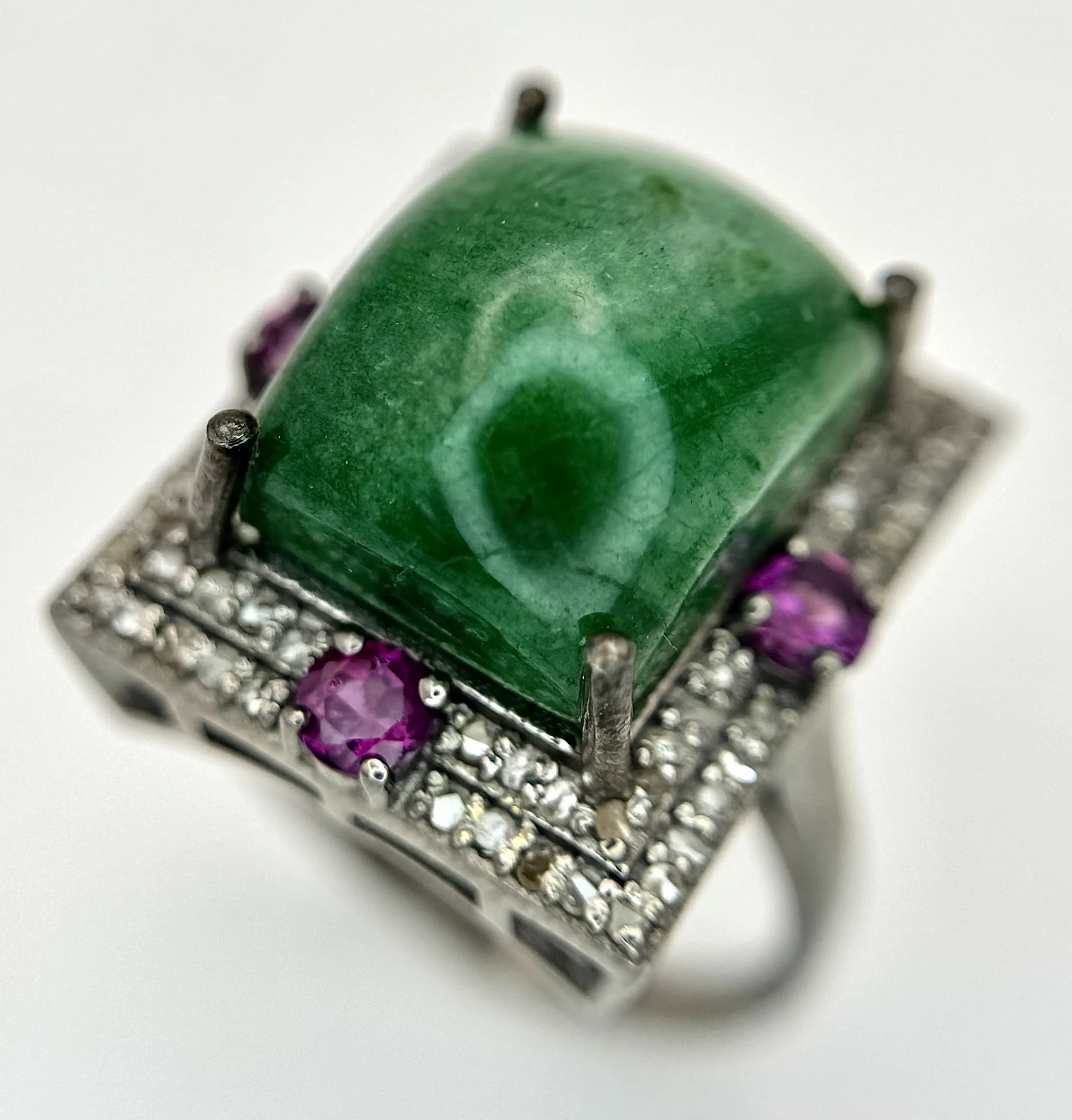 A 10ct Cabochon Emerald Ring with Diamond Surround and Ruby Accents, set in 925 Silver. Size O. 6.6g. CD-2139.
