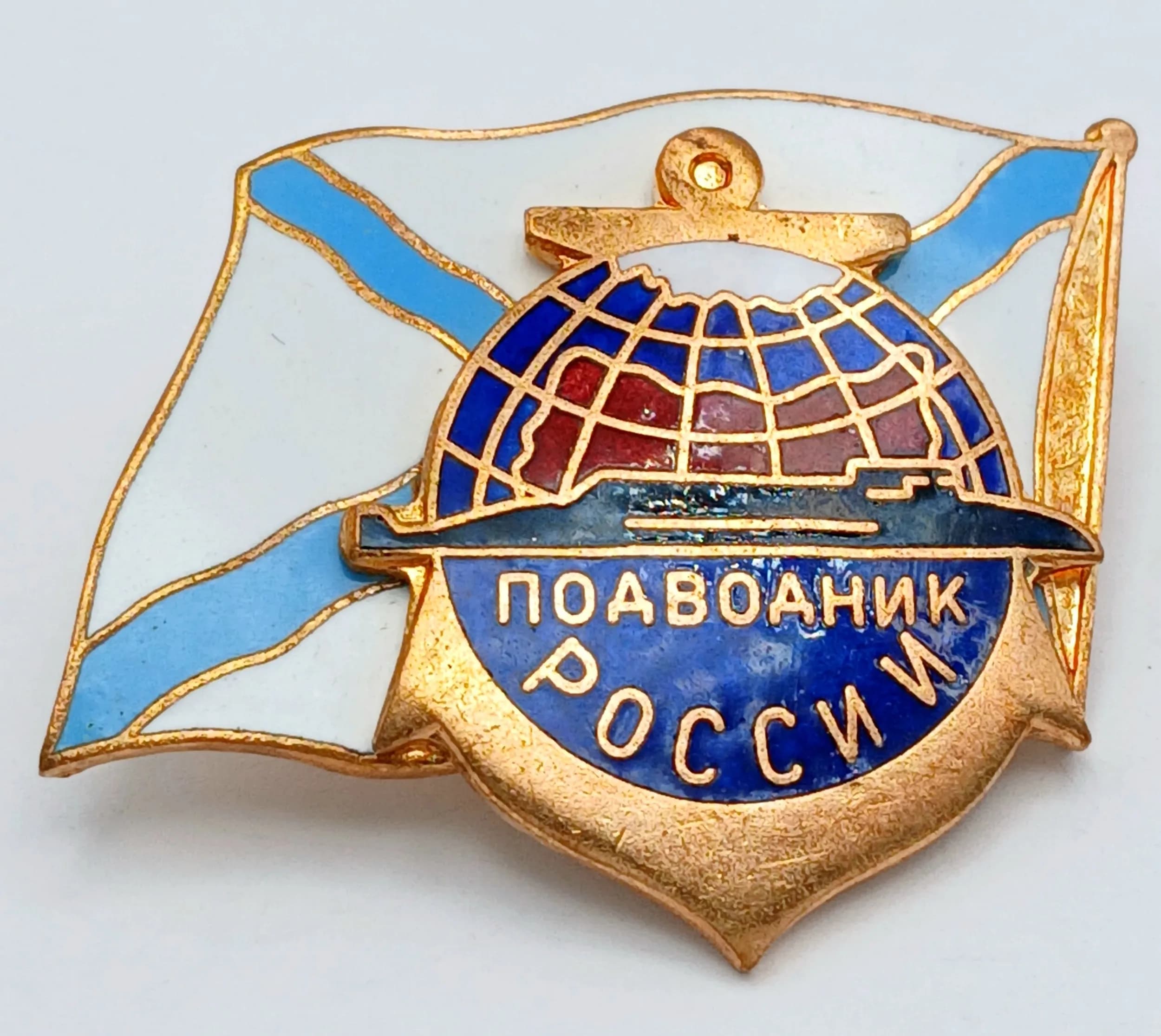 A Russian Submarine Breast Badge. Brass construction with hot-enamelled decoration, featuring a submarine motif and naval flag design. Screw back type with multi-level construction.