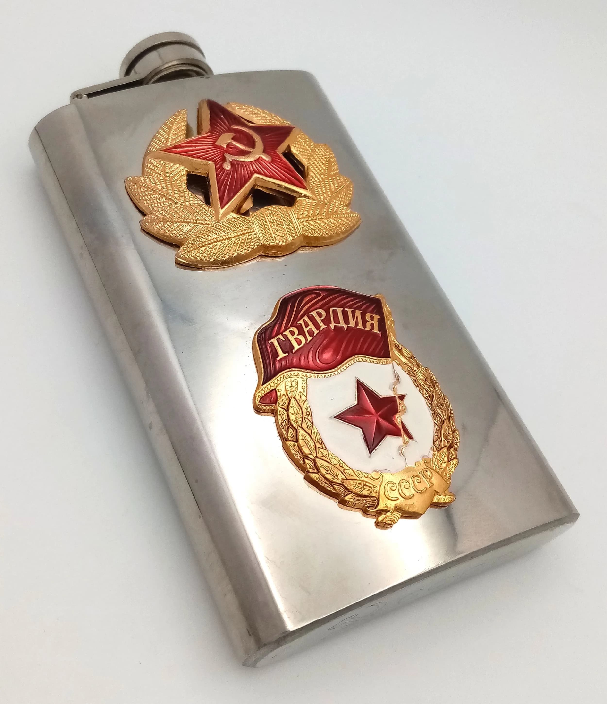 A Russian Military Style Stainless Steel Flask. Features two decorative Russian military style badges to the front. 6oz capacity. Unused condition.